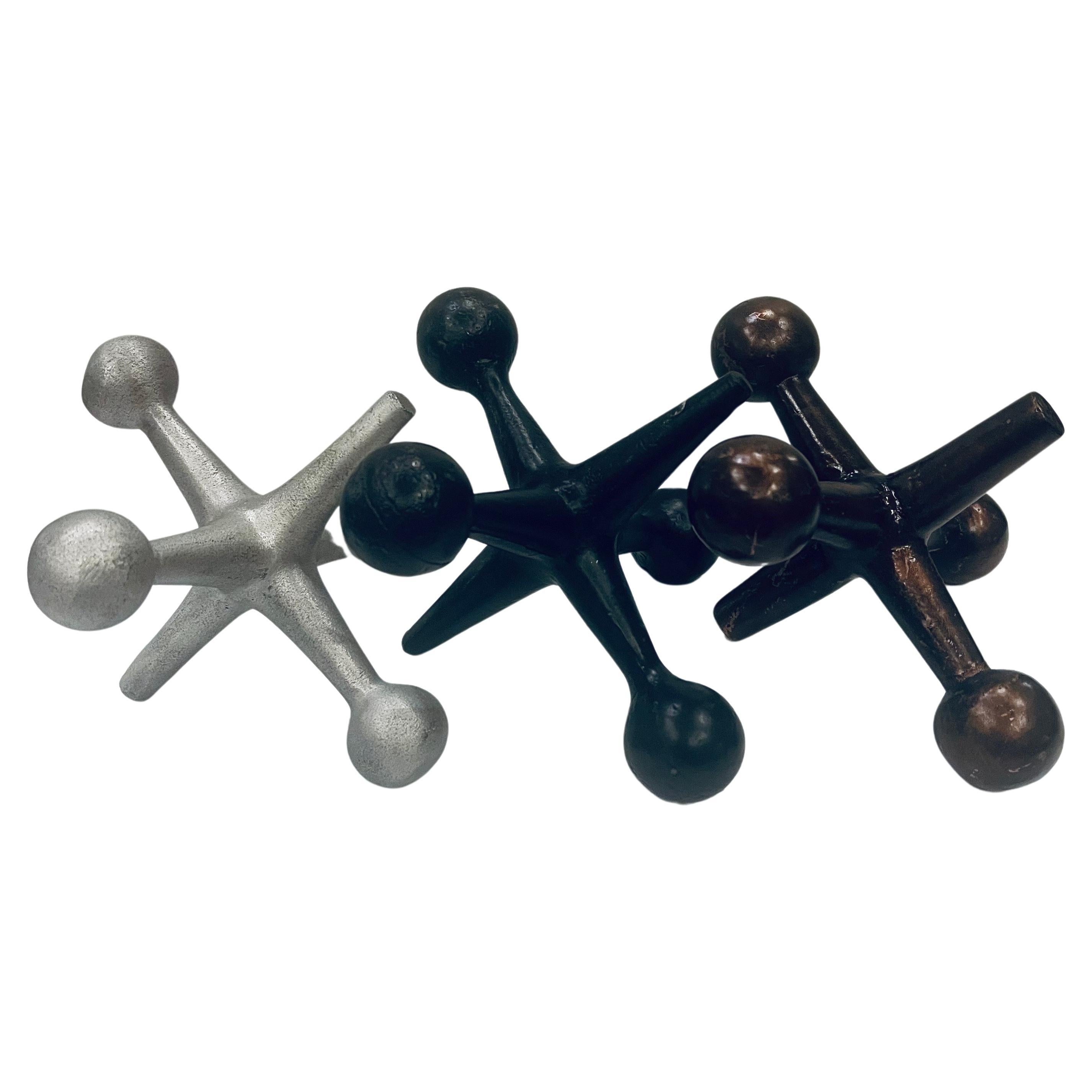 Set of three 1950s atomic era, Mid-Century Modern iron jacks-jax. The pieces can be used as bookends, a doorstop, or decorative accents. in aluminum, black and bronze finish with a nice well-worn patina.