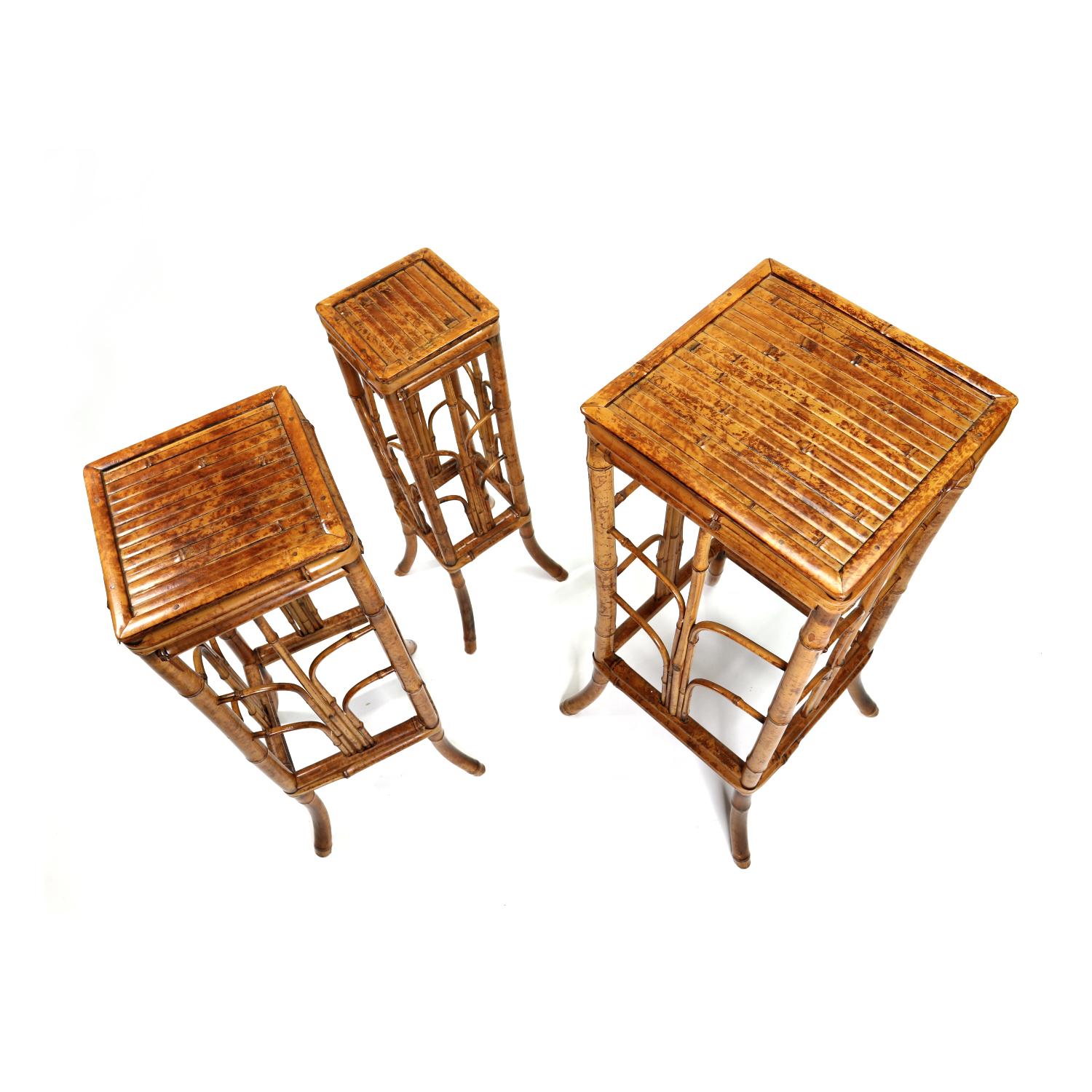 Handsome set of three vintage Bohemian bamboo plant stands. The group consists of three plant stands of graduating size. The trendy boho stands are made of tortoiseshell bamboo. The bamboo gets its name for the unique pattern resembling the back of