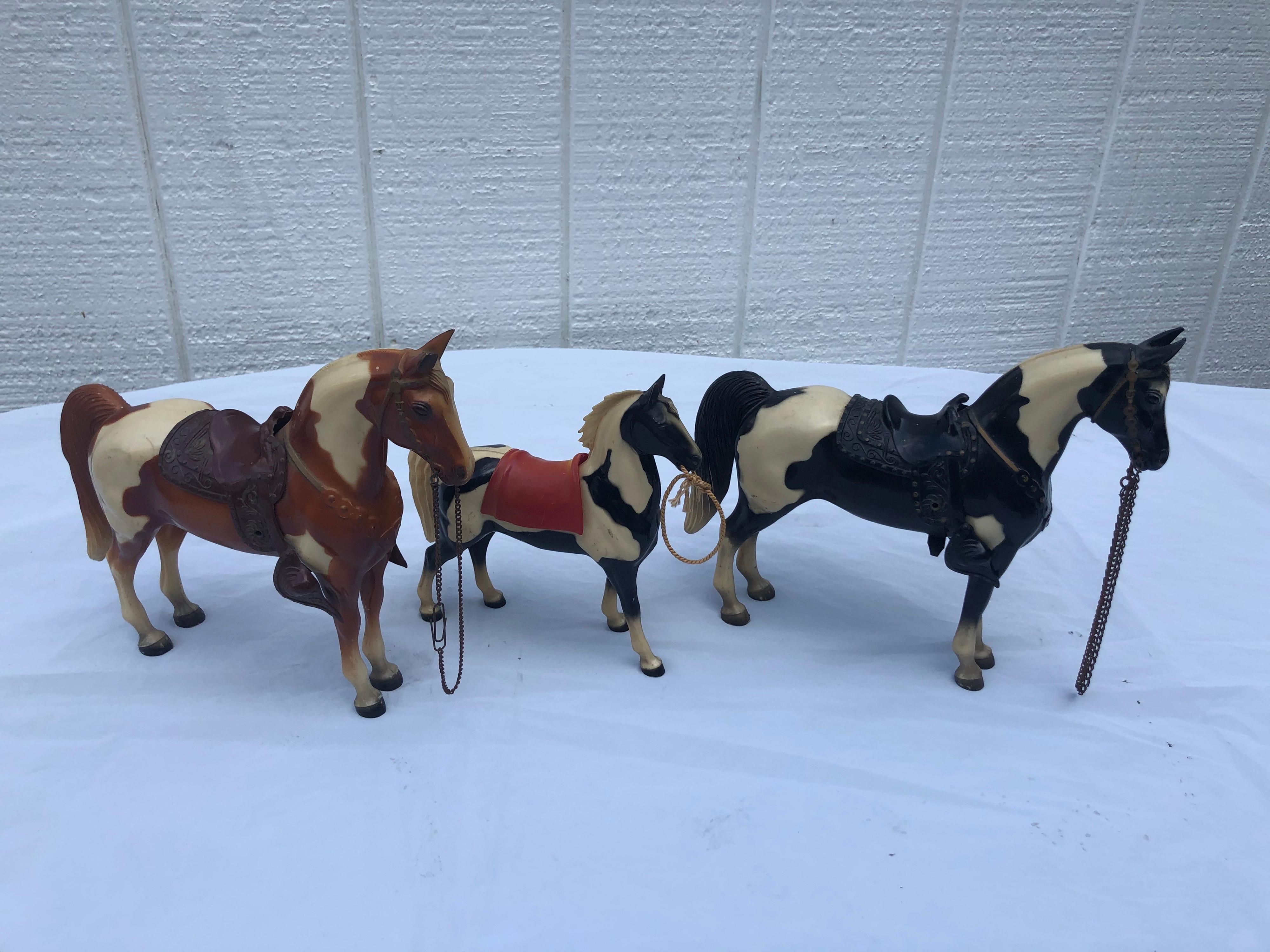 Set of three vintage Breyer Western Toy Horses. Possibly #57. We do believe these to be early Breyers before the molding company started branding them on the inner thigh. They come with harnesses and saddles . The larger horses are 10
