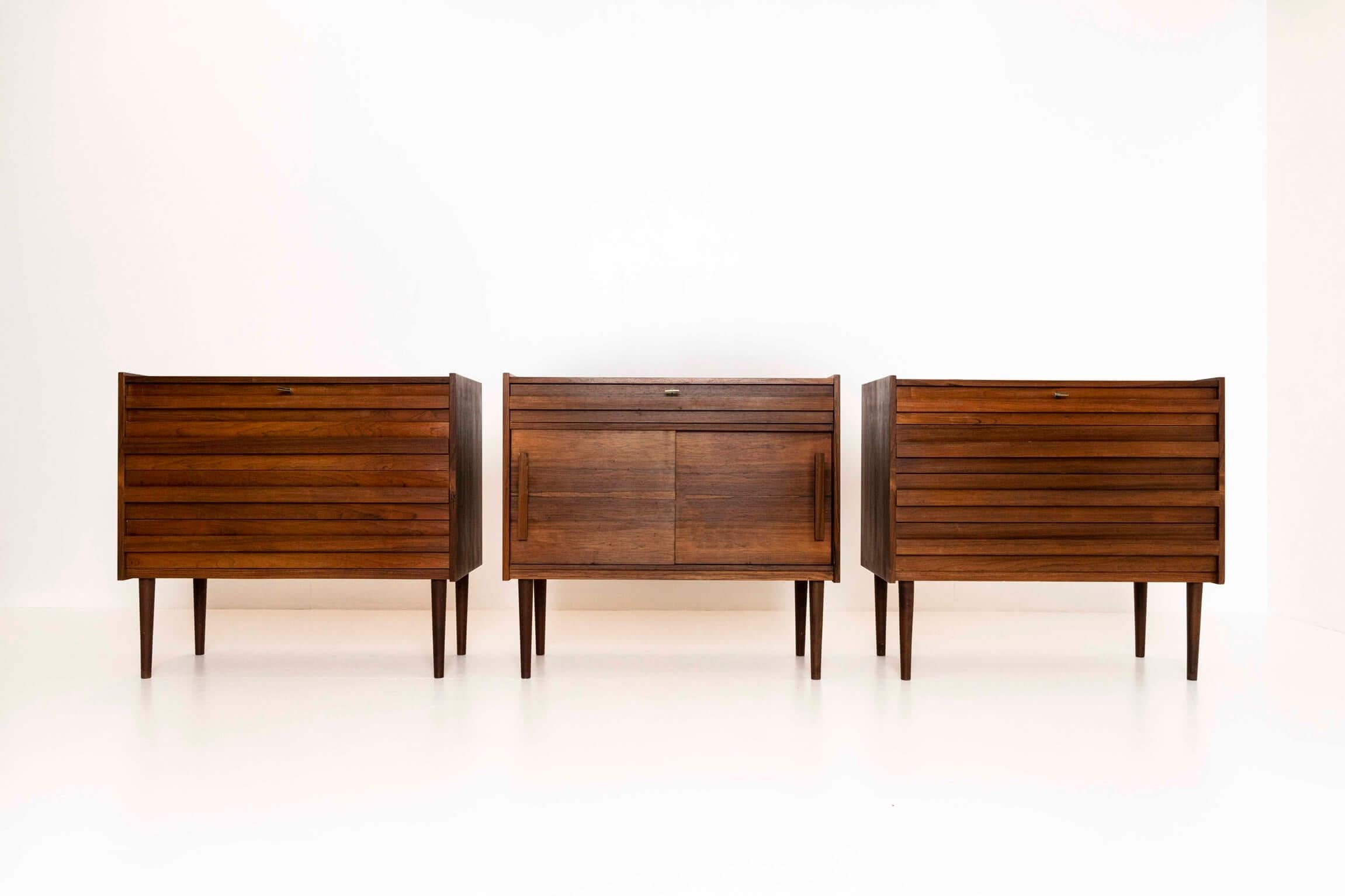 Rare set of three vintage cabinets in veneered rosewood from Denmark, most probably the 1960s. This set consists of two identical chests of drawers and a small dresser. The cabinets can be used all together as a sideboard or separate in a room. The