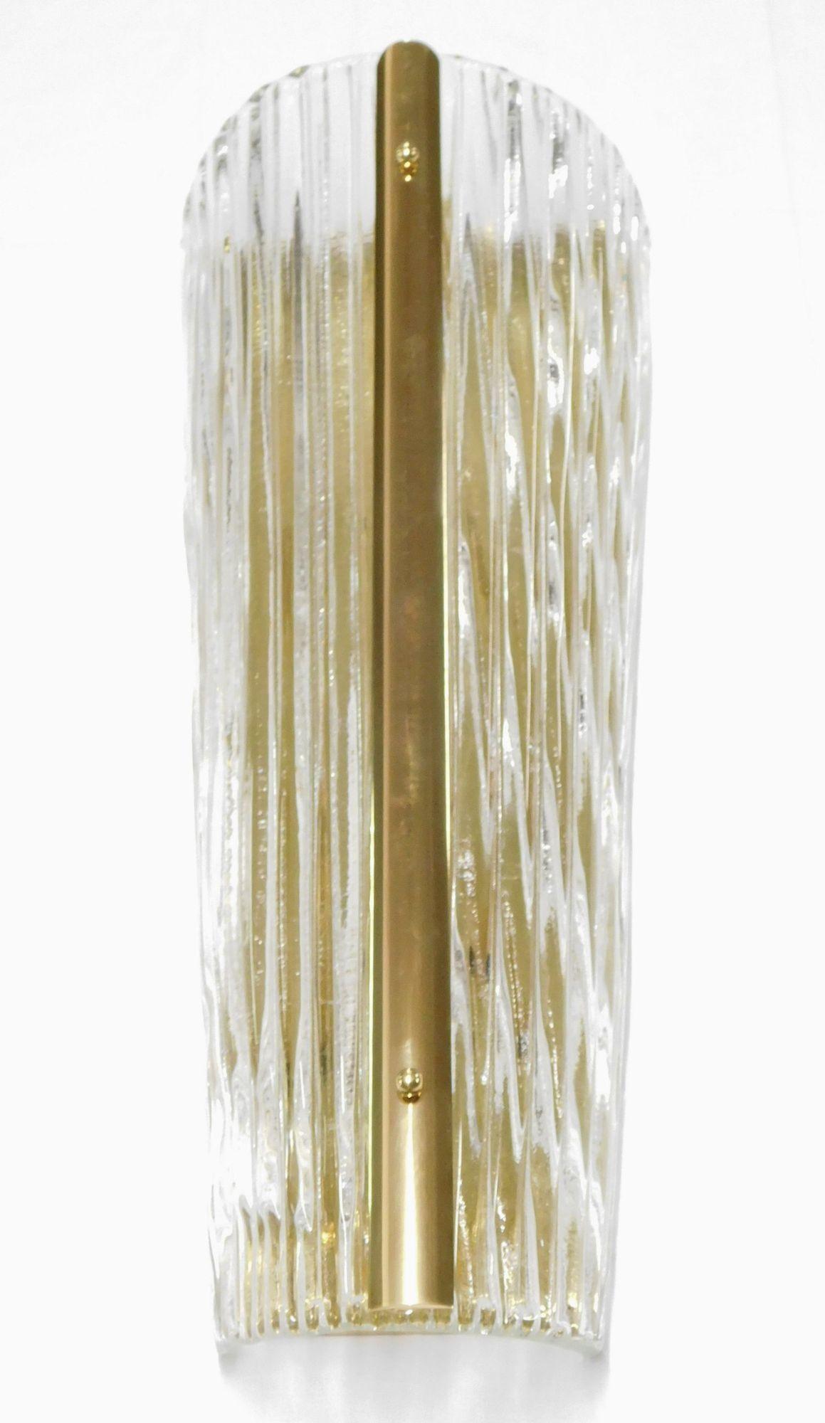 Ein Satz von drei italienischen Wandleuchten aus mundgeblasenem Murano-Glas, jede auf einem polierten Messingrahmen montiert. Das Murano-Glas wird in einem einzigartigen gebogenen Design mit linierten Mustern mundgeblasen.
*Neu verkabelt, um den