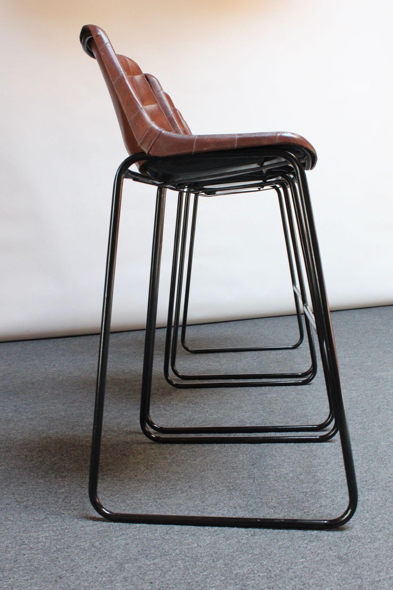 Set of three richly patinated barstools with leatherette seats supported by wrought iron and steel frames with footrests (ca. 1970s, Italy). Though the maker is unknown, contemporary adaptations of these stools have been made within the last several