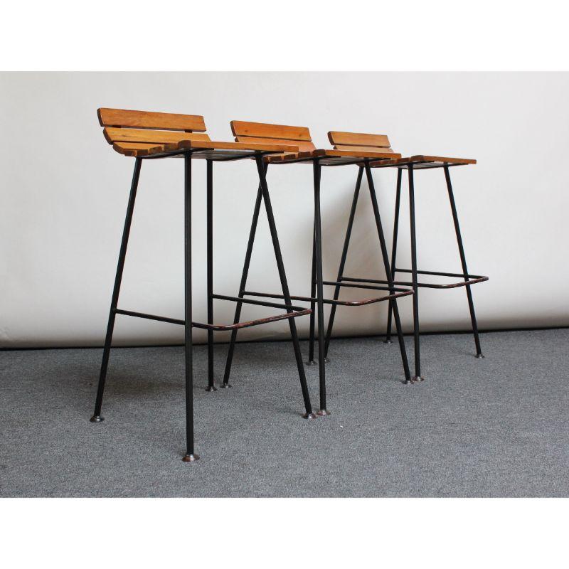 Organic form bar stools with a slatted maple seat / back rest supported by wrought iron frames with foot rests (ca.1950, likely East Asian). These were said to have been moved to the United States by the previous owners from a Korea Nightclub after