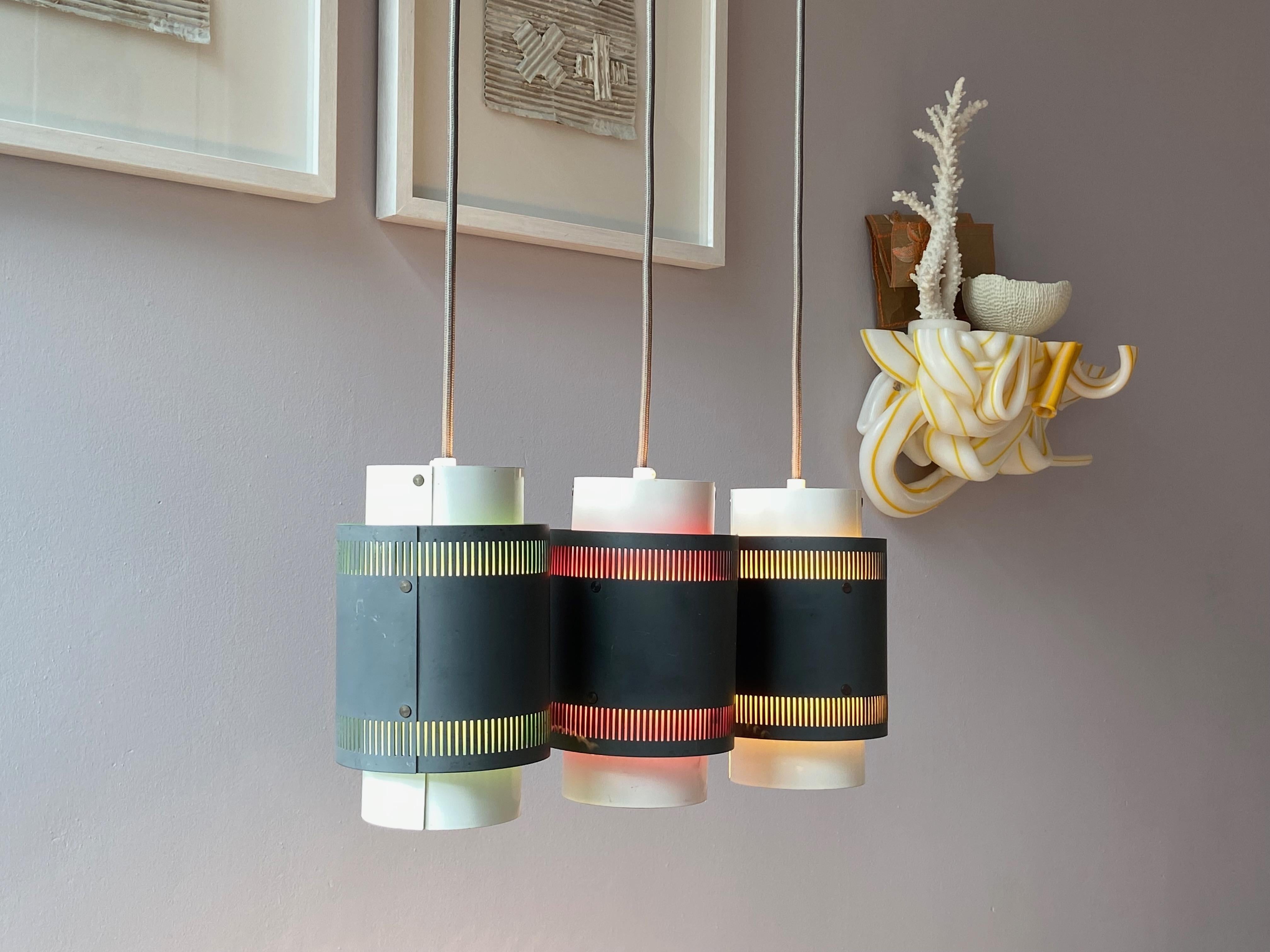 Nice set of three pendant lamps from the 1960's, Made in Denmark. Inside in yellow, red and green, outside grey and white with 1x E26/27 Edison screw socket in original condition. No parts missing, with new grey fabric cord, ready to use with 110