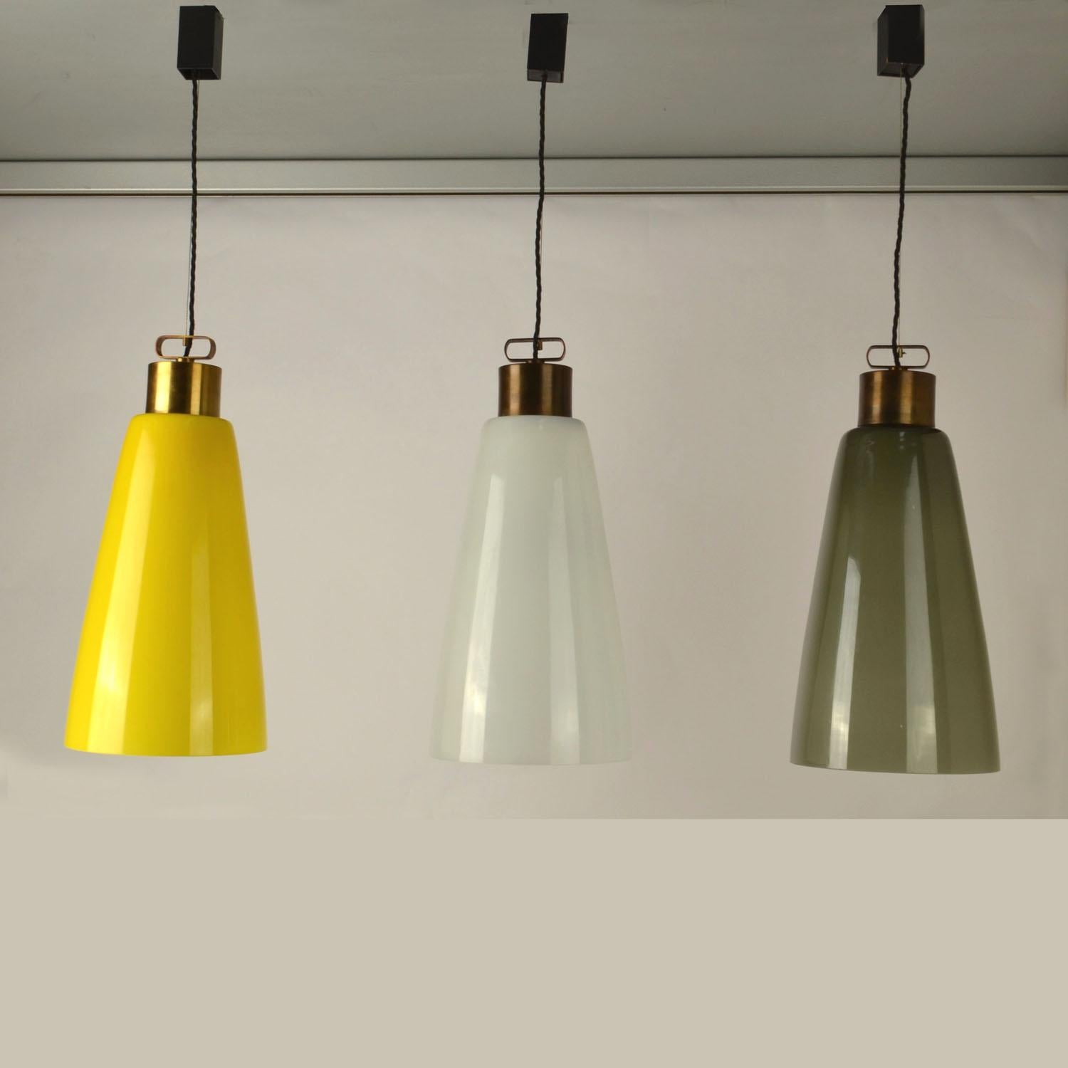 Set di tre lampade da soffitto a forma di campana nei colori giallo, bianco e grigio di Carlo Nason degli anni '50, sospese su supporti in ottone regolabili. Il vetro giallo e grigio è sovrapposto al vetro bianco per riflettere la stessa luce con