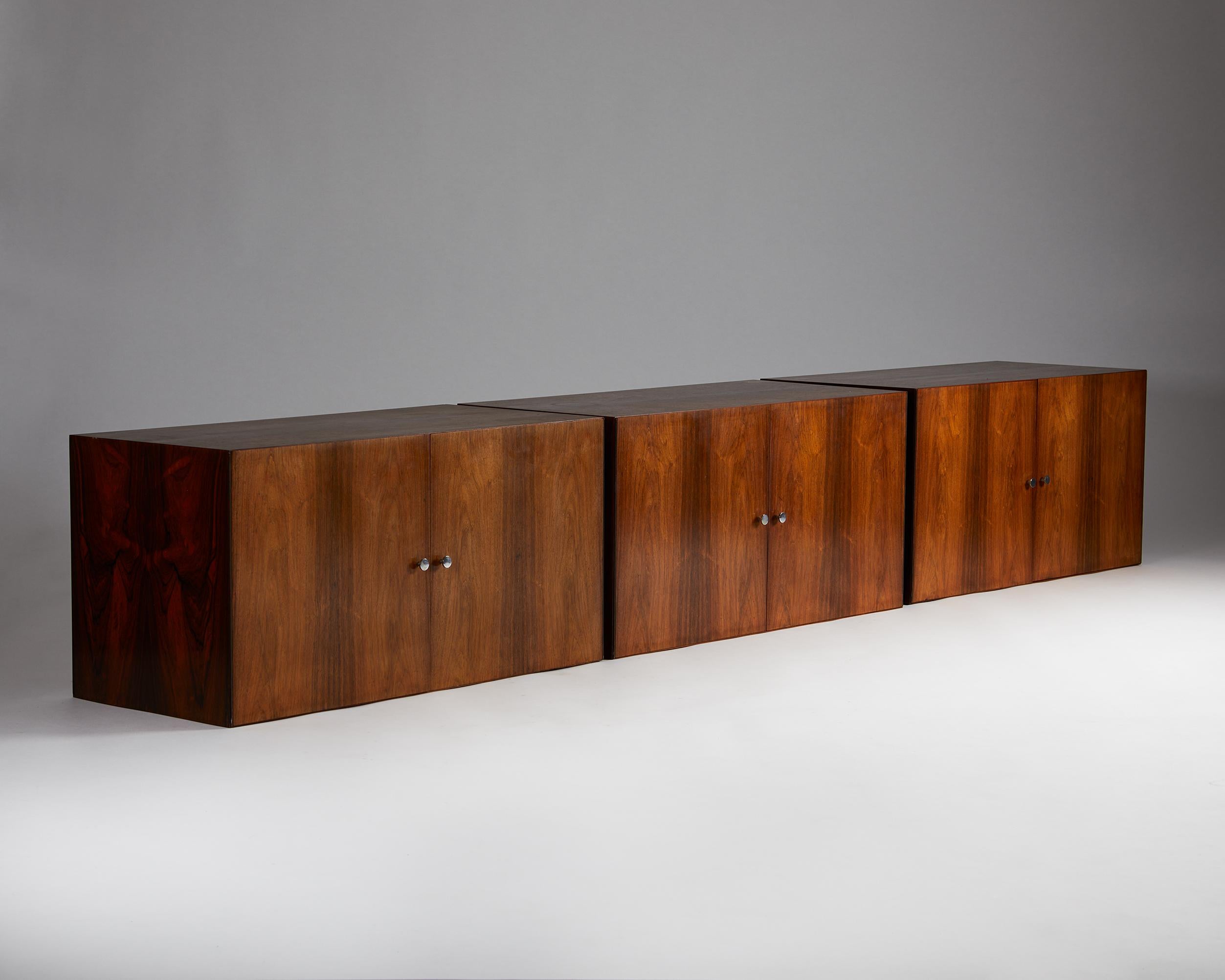 Set of three wall hung sideboards designed by Poul Nørreklit for Sigurd Hansen,
Denmark. 1960s.
Brazilian rosewood and steel.

Stamped.

Combining functionality with sophistication, this sizeable rosewood collectable from the 1960s consists of