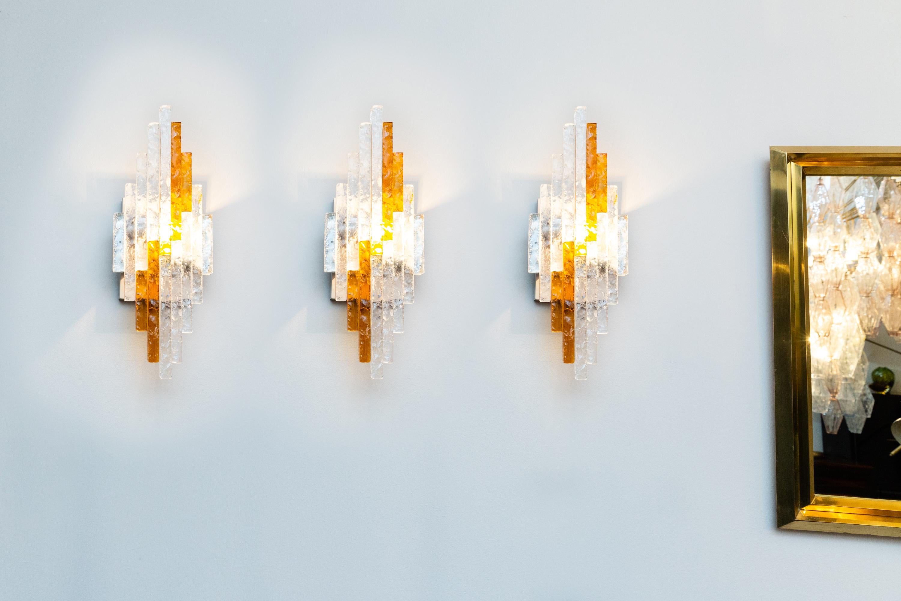 Three wall lamps by Albano Poli
Chromed metal, colored and transparent glass elements.
Prod. Poliarte, Italy, 1970s
Very good condition. Measures: cm 50 x 20 x 10.