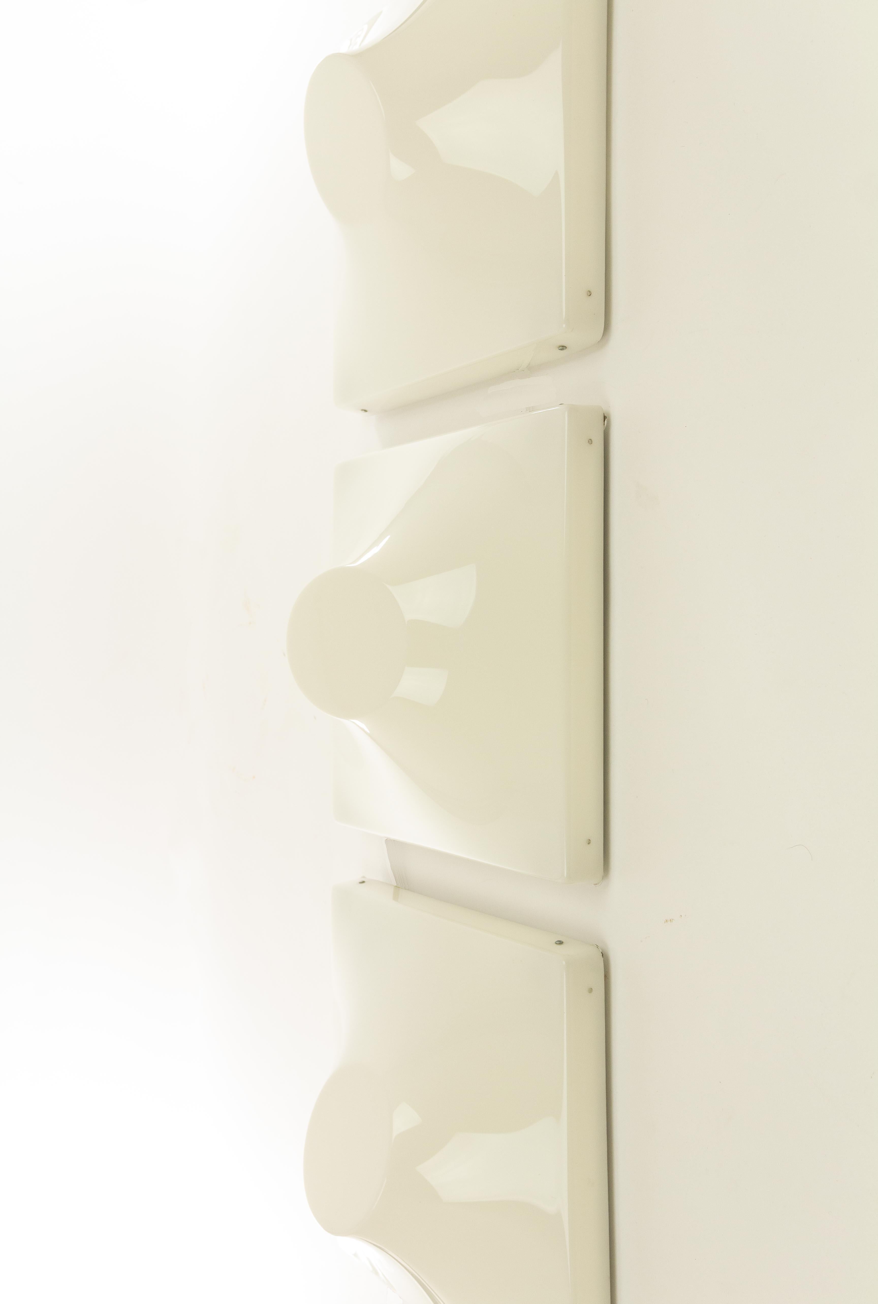 Set of three wall lamps designed by Ennio Chiggio and produced by Emmezeta in the 1970s.

The lamps consist of two parts; a metal structure that can be attached to the wall and a three-dimensional plastic front that can be clicked to the metal