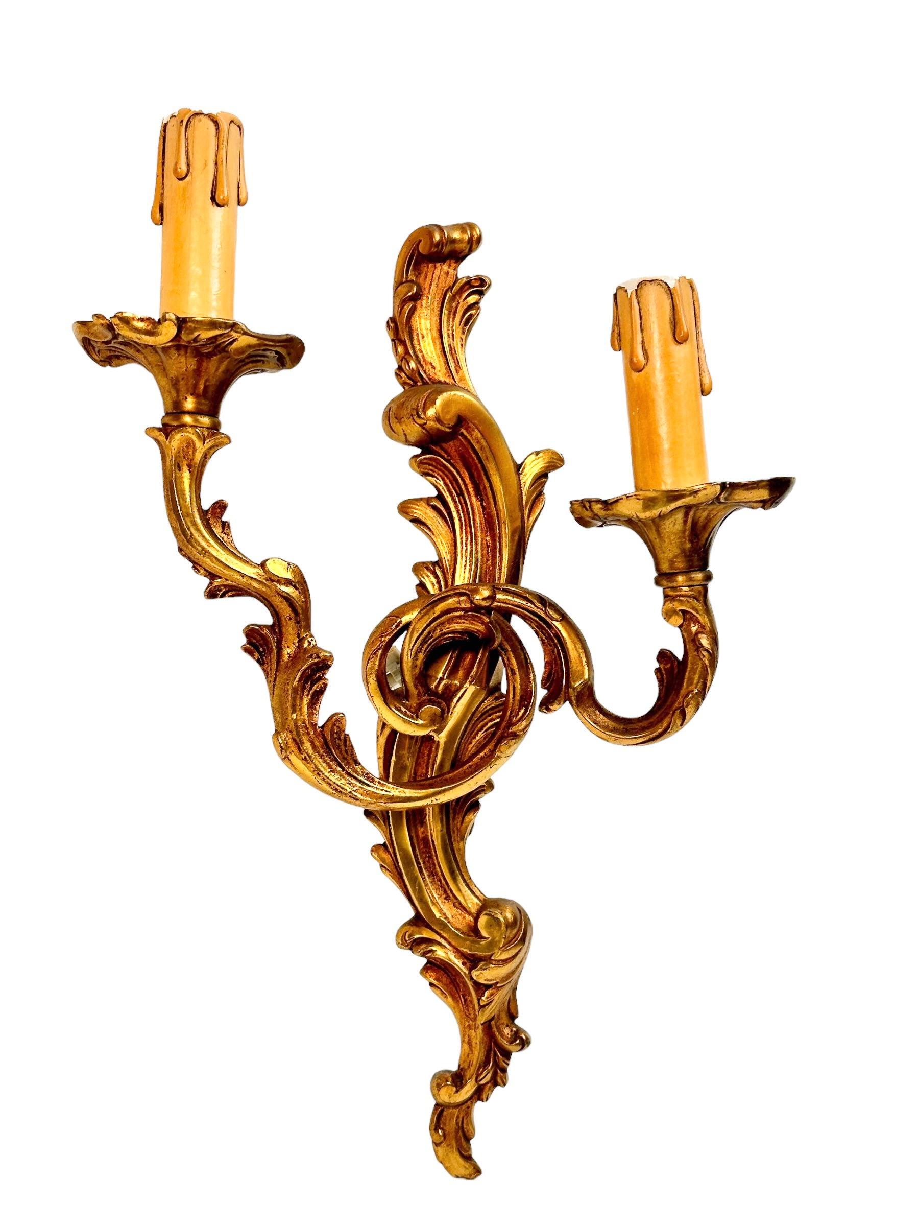 A nice set of three sconces with 2 light sources, made of bronze with decoration of acanthus leaves. Each fixture requires two European E14 candelabra bulbs, each up to 40 watts. The wall lights have a beautiful patina and gives each room an