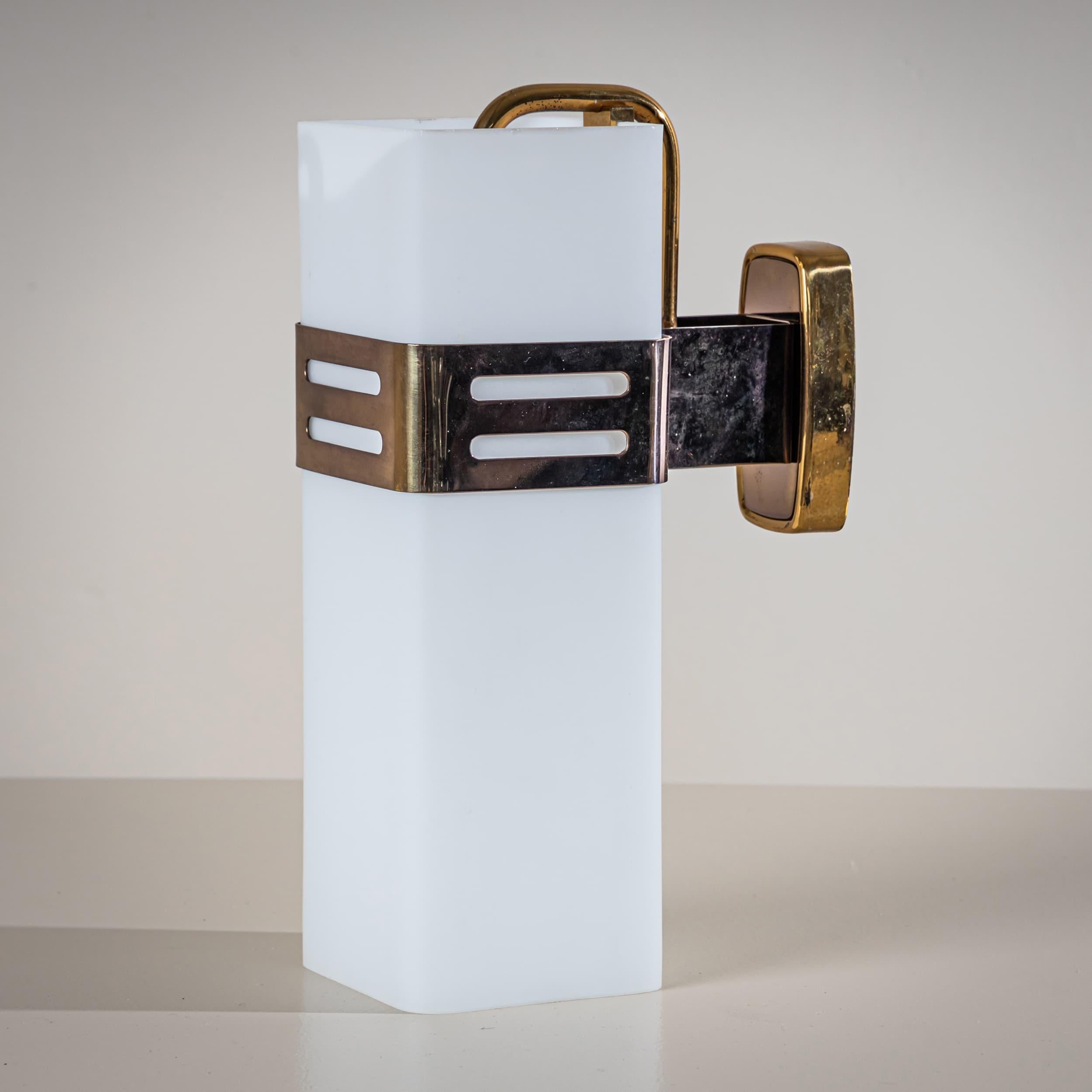 Ensemble de trois élégantes appliques murales dotées d'un abat-jour rectangulaire en verre opalin et de ferrures en laiton. Chaque support mural porte le Label original de Stilnovo. Conçue et produite par le célèbre fabricant milanais Stilnovo dans