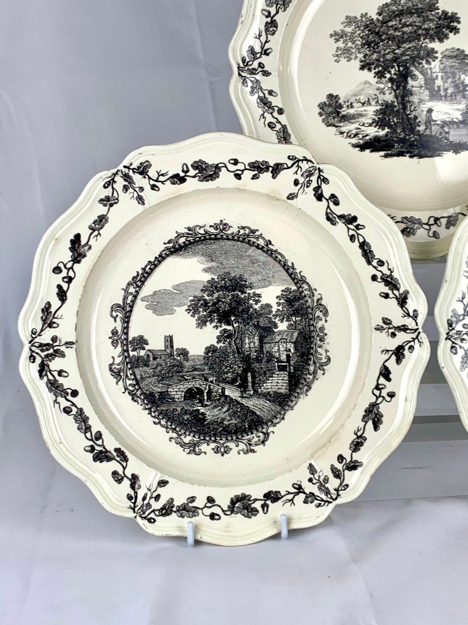Questo raro set di tre piatti di crema è stato realizzato in Inghilterra da Wedgwood nel XVIII secolo, intorno al 1780.
Ogni piatto è decorato con un paesaggio finemente dettagliato stampato a trasferimento in nero da Sadler & Green, reso in una