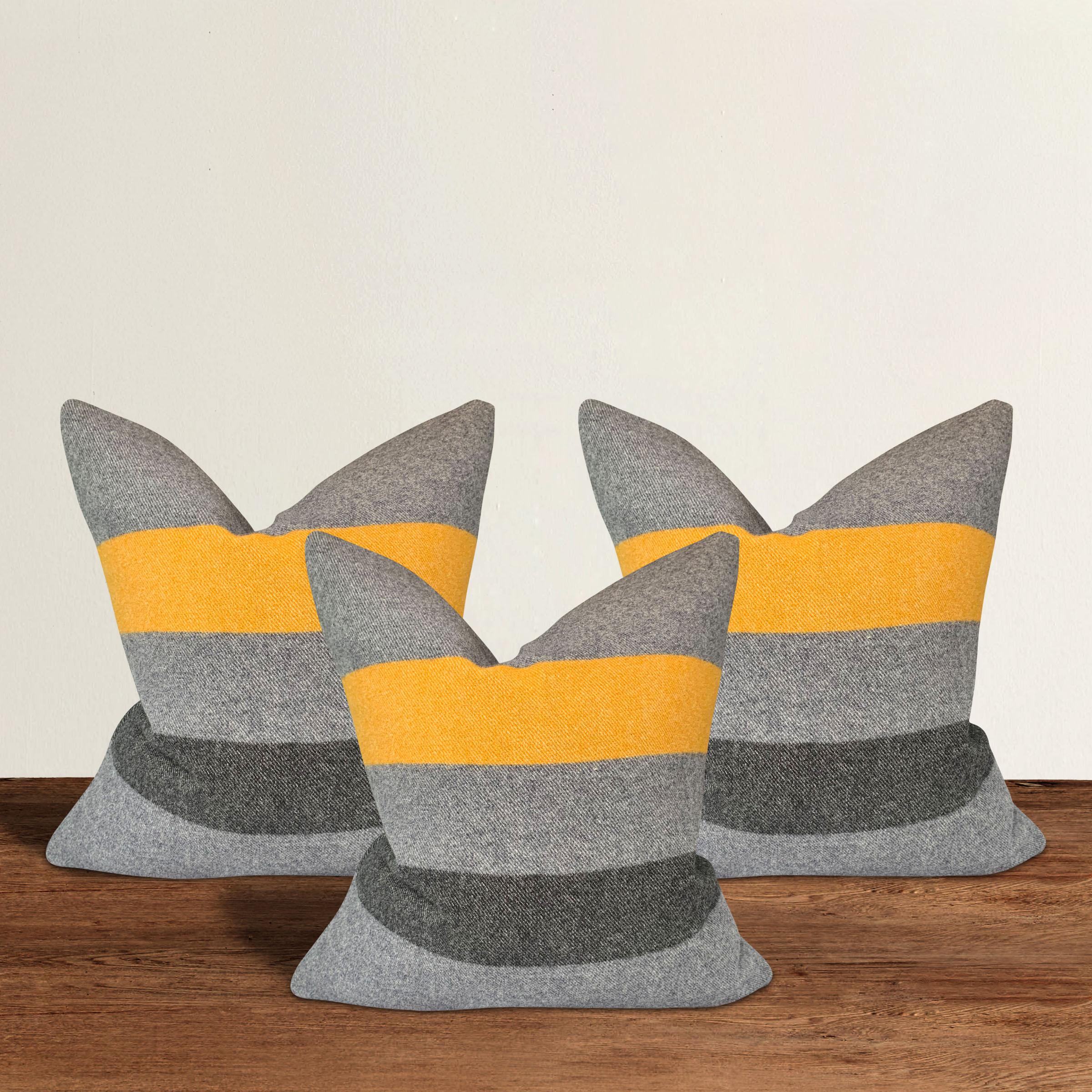 A wonderful set of three pillows with gold and black stripes against a gray background, custom made from wool sourced from Faribault Woolen Mills in Faribault, Minnesota. Faribault Woolen Mills was founded in 1865 along the Cannon River in