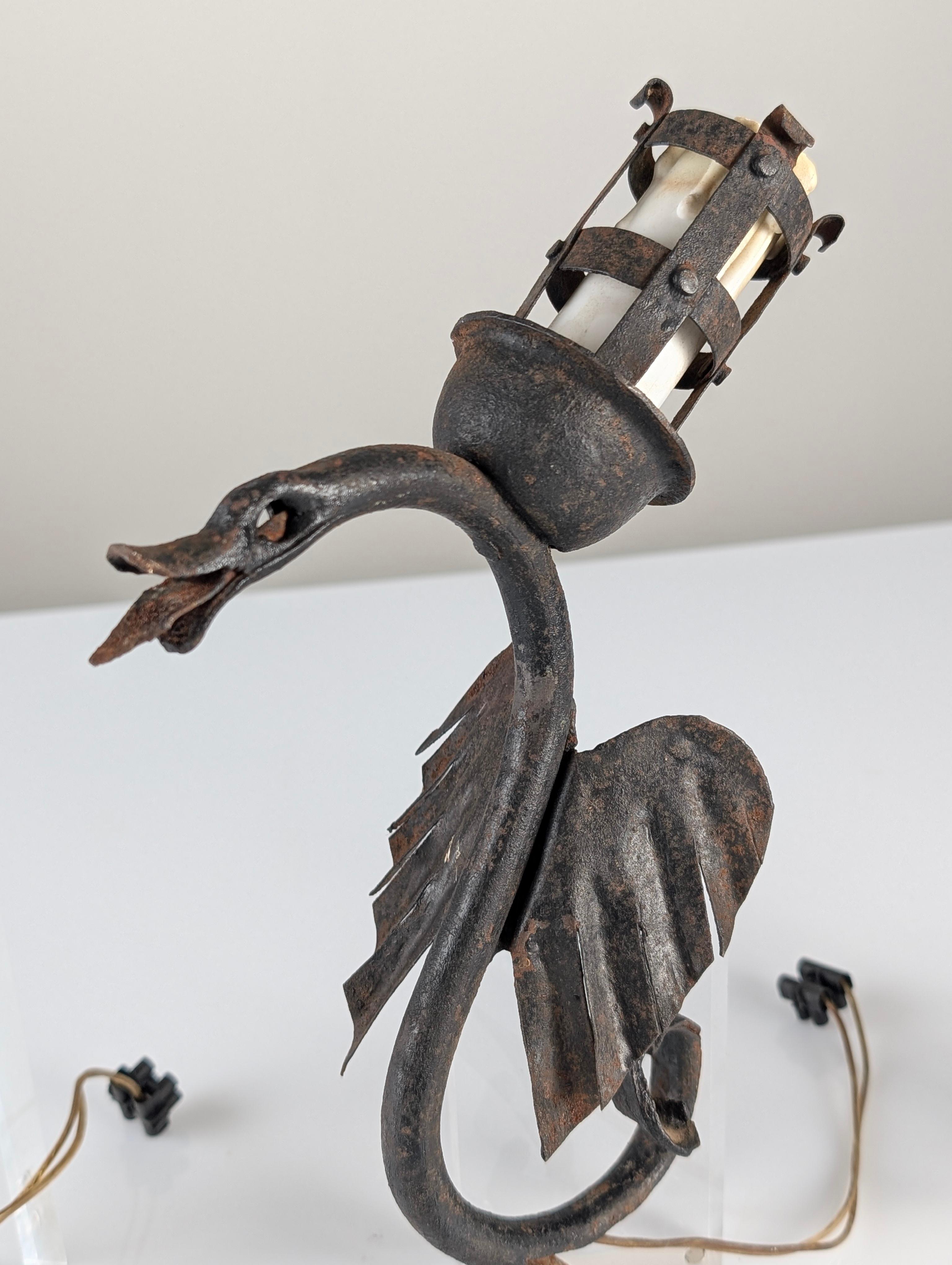 Este conjunto de tres apliques en forma de dragón capta la esencia del diseño artesanal en hierro forjado de principios de siglo. Cada candelabro, con su elegante curvatura y sus estilizadas alas, evoca un espíritu mítico que resalta el refinamiento