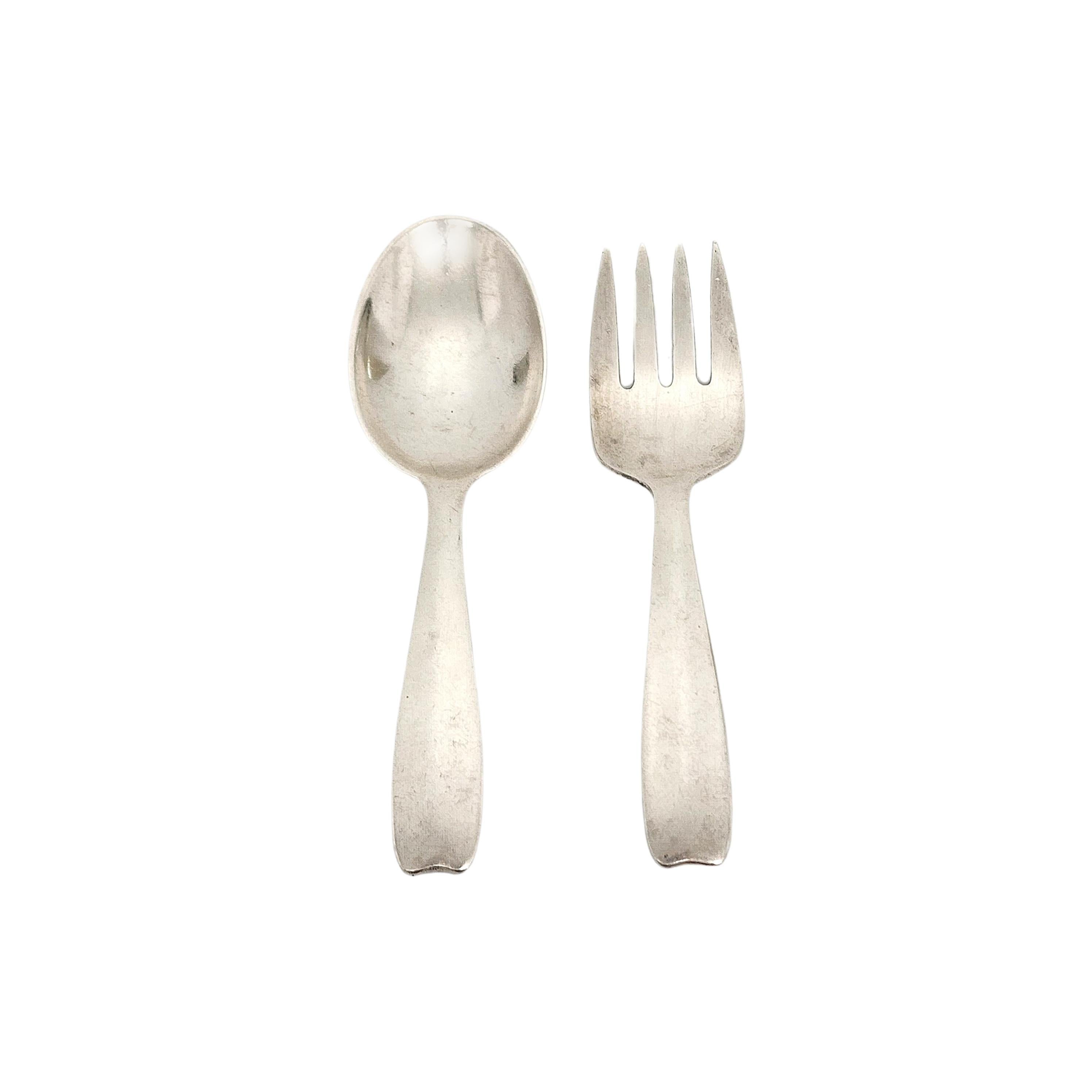 Set of Tiffany & Co sterling silver child/baby infant feeding spoon and fork in the Cordis pattern.

Cordis is a simple and classic design. No monogram or engraving. The M mark dates this piece to manufacture under the directorship of John C. Moore,