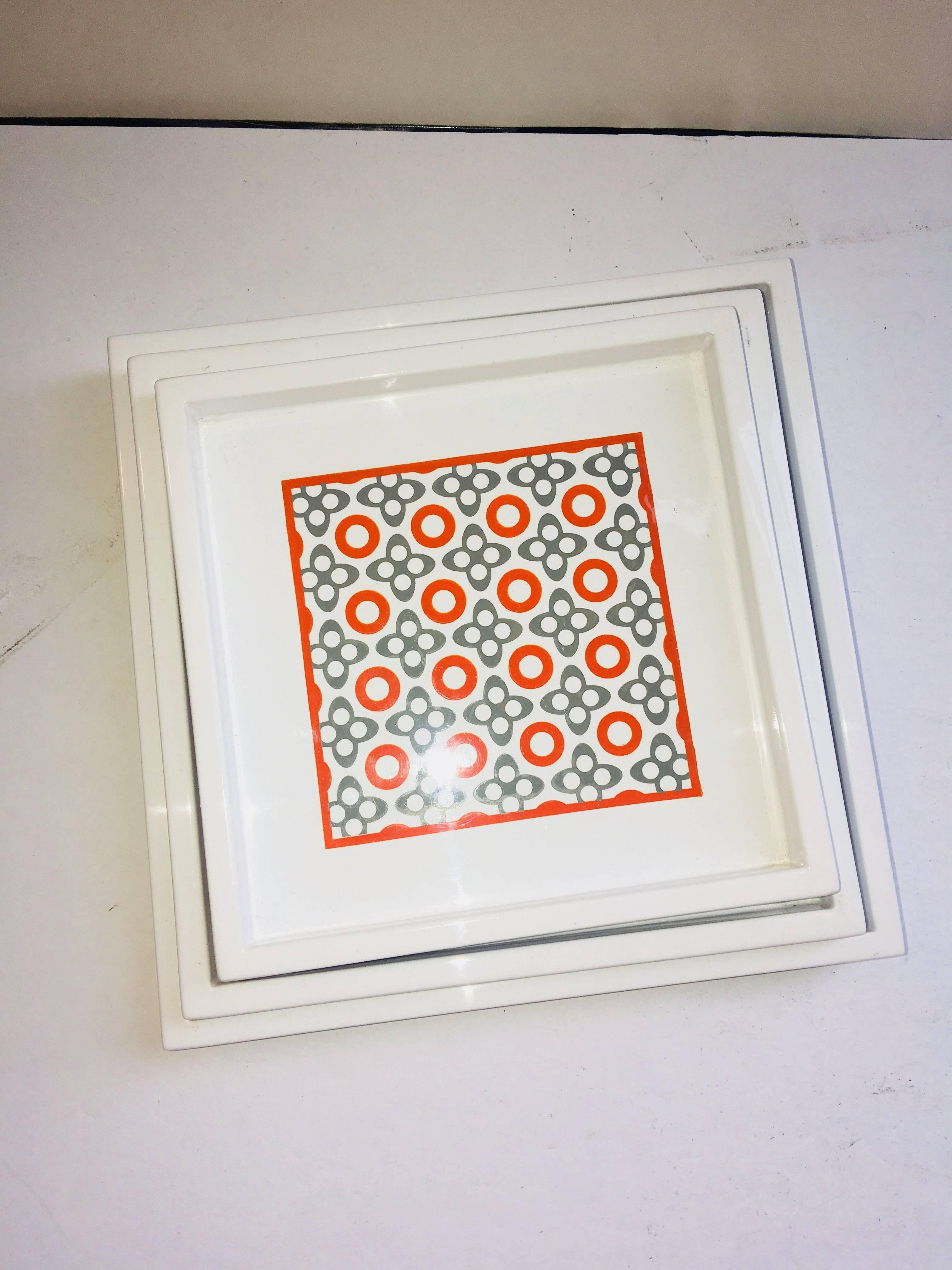 Set of three trays that fit within one another with Geometric funky print in orange and grey.
Measures: Smallest tray 5.5