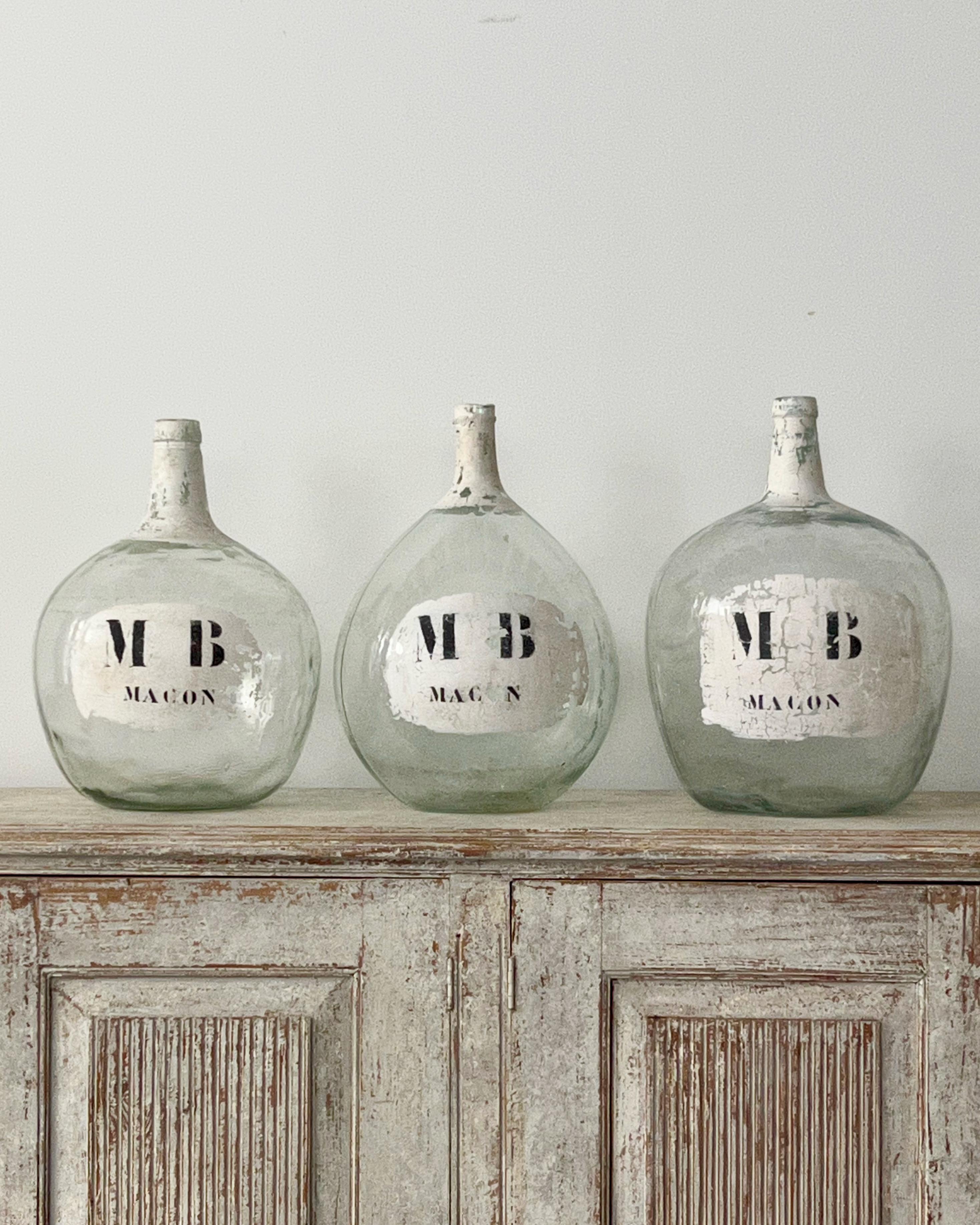 Set of three 19th century large blown Dame Jeanne, clear glass bottles
Set of three different sizes hand blown wine bottles. All three are hand blown with painted winery labels 