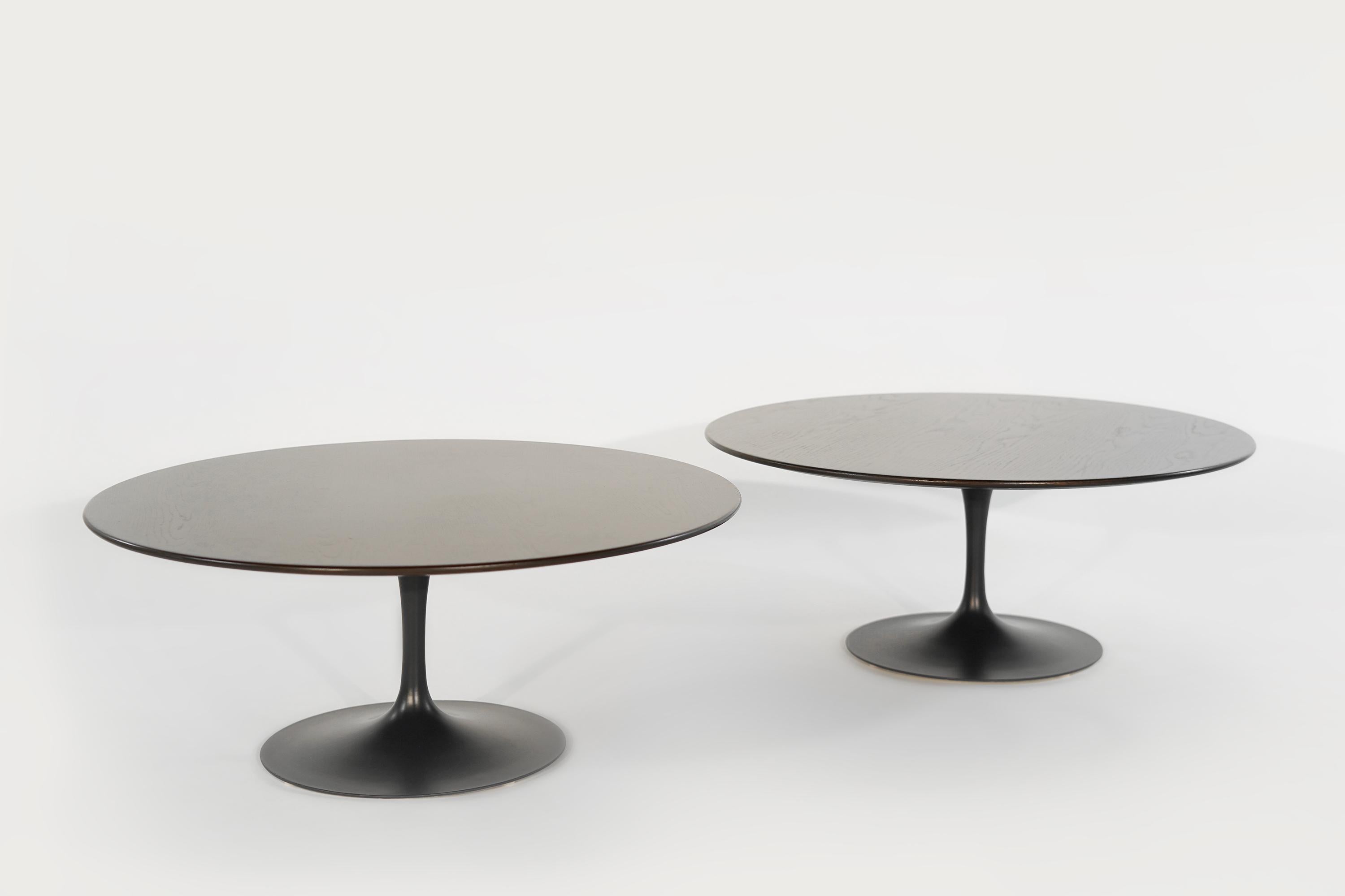 Beautiful and rare matched set of coffee tables designed by Eero Saarinen for Knoll, circa 1960s. Featuring newly refinished 36-inch oak tops and cast iron bases redone in matt black. Priced individually.
