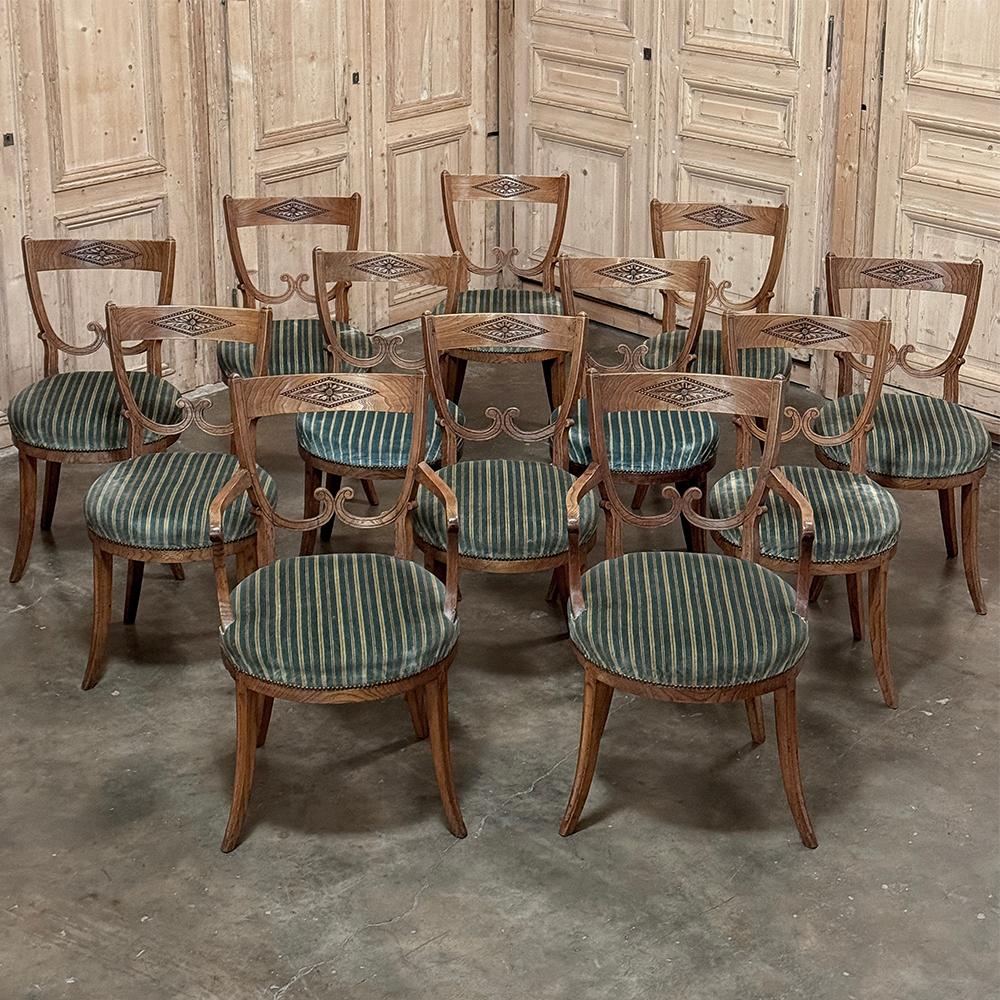 Set of Twelve 18th Century Swedish Gustavian Dining Chairs includes 2 Armchairs were built to grace an elegant mansion in Sweden, now ready to add style, flair and timeless elegance to your own dining experience!  The shield-back seats all feature a