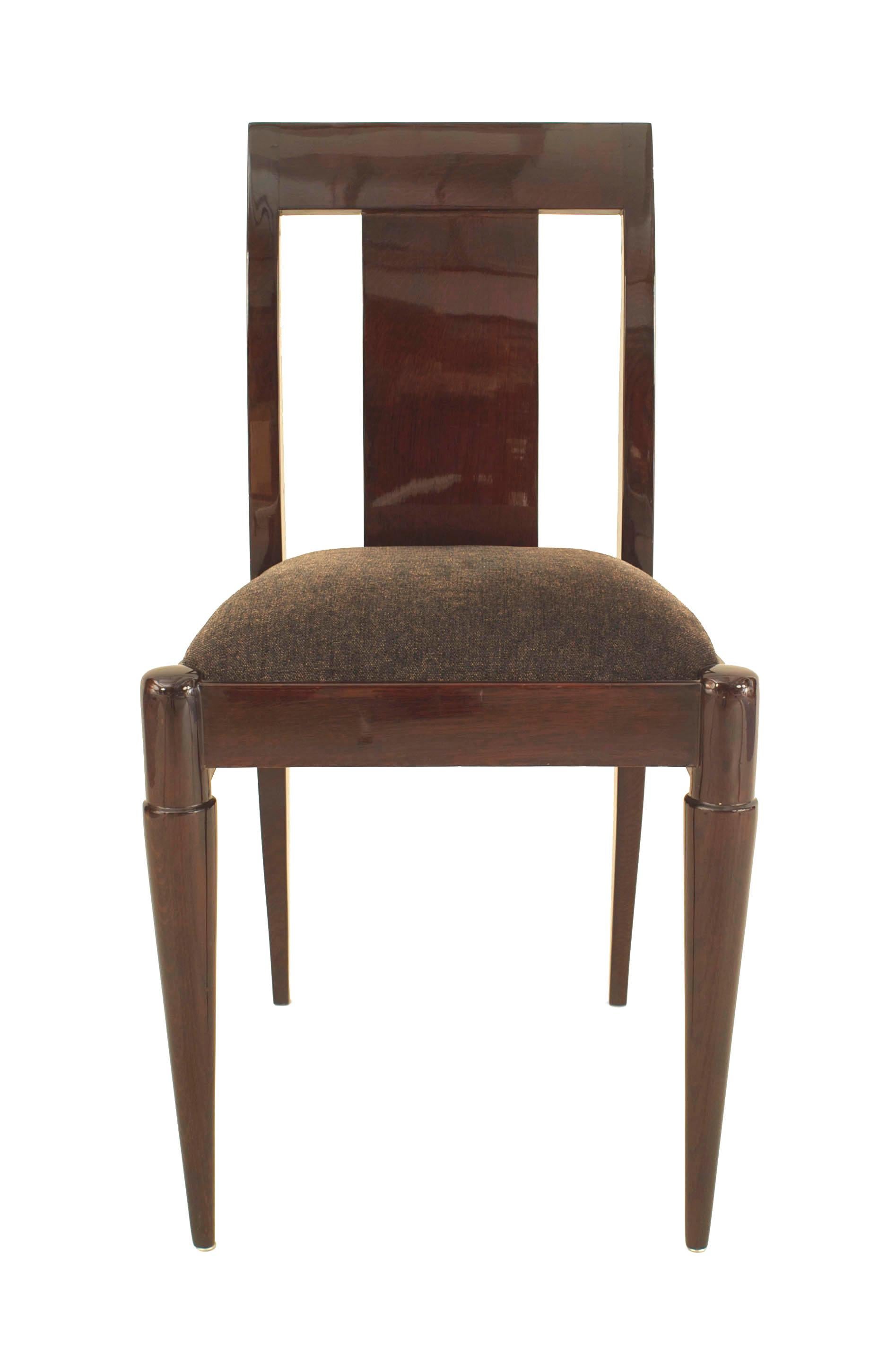 Set of 12 French side chairs. These stained mahogany side chairs were designed with square backs, center panels and upholstered seats each supported by four round tapered legs.
