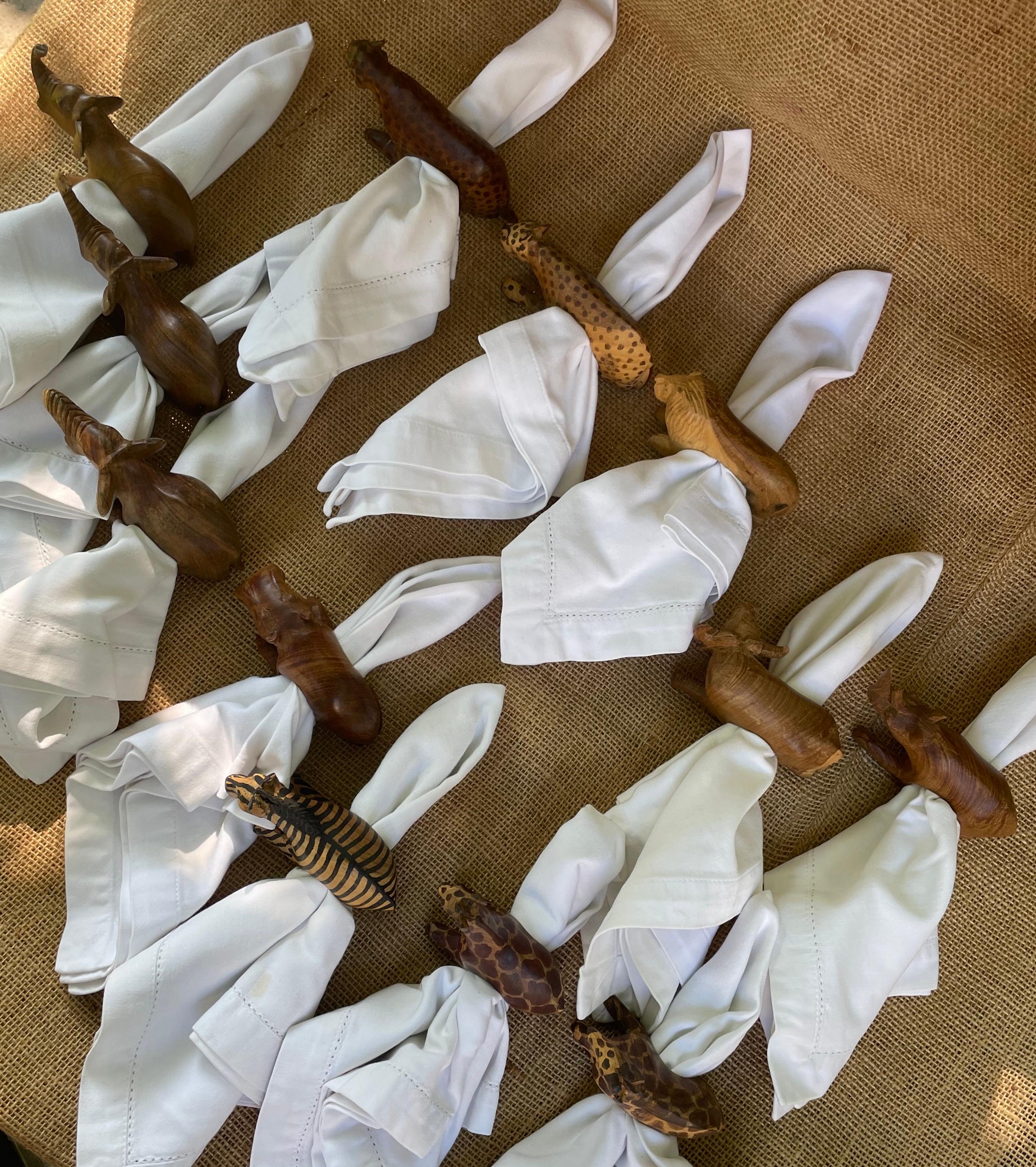 Set of twelve African Safari napkin rings. Hand carved and stained olive wood figures with integral rings from Kenya consisting of pair cheetah, pair giraffe, pair elephants and a baby, hippo, lion, water buffalo, zebra and a rhinoceros. Mount Kenya