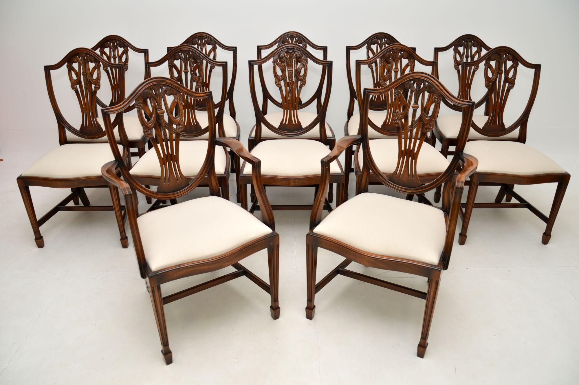 A fantastic set of twelve antique shield back dining chairs. They were made in England, and date from around the 1950’s.

The quality is outstanding, the pierced shield backs have intricate Prince of Wales feather carving, they have serpentine
