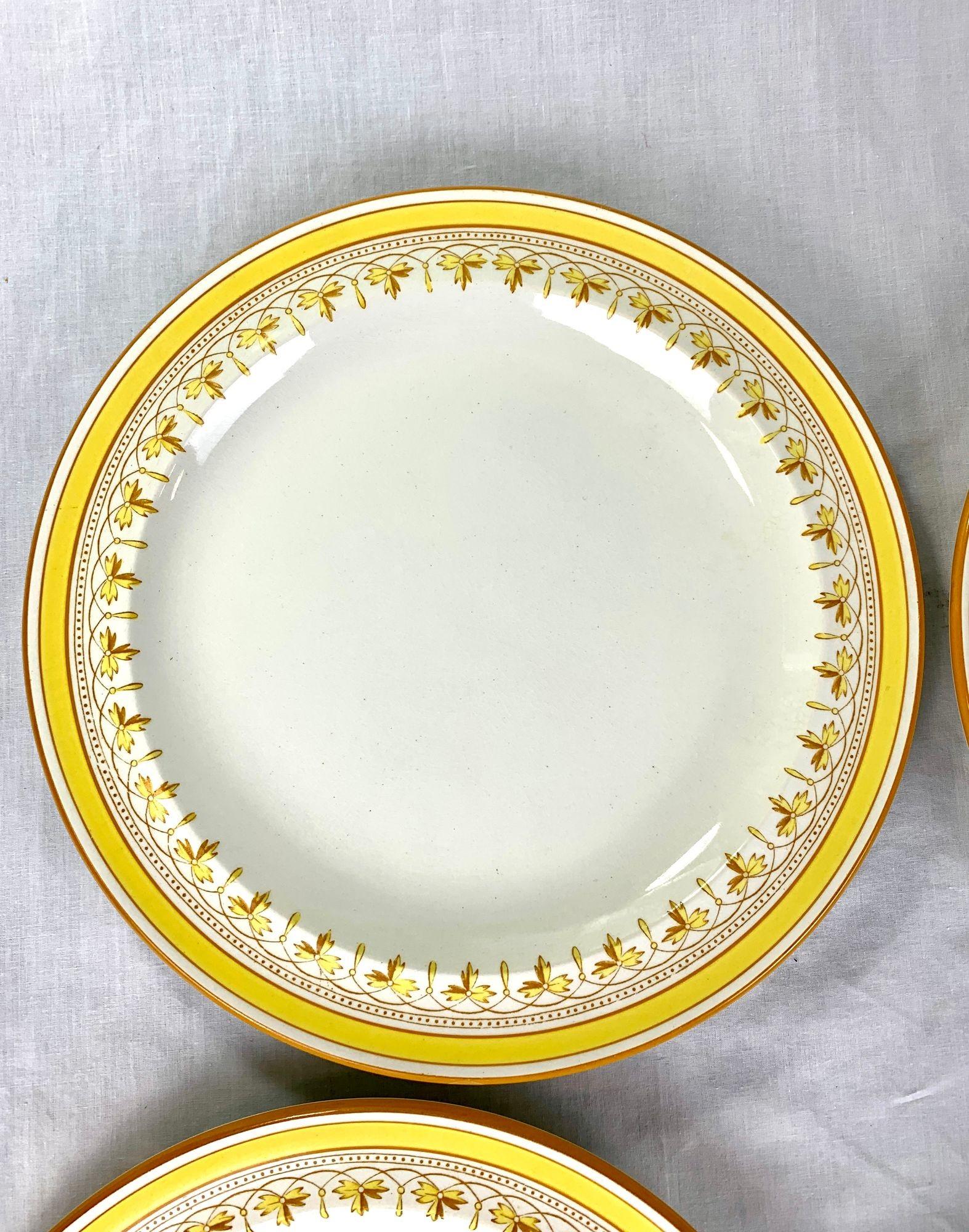 Dieser Satz von zwölf Wedgwood-Speisetellern ist mit der Datumsangabe 1879 versehen und zeichnet sich durch seine fröhlichen gelben Ränder und das elegante Band aus stilisierten Lilien aus.
Die Kombination aus leuchtenden Farben und raffinierten
