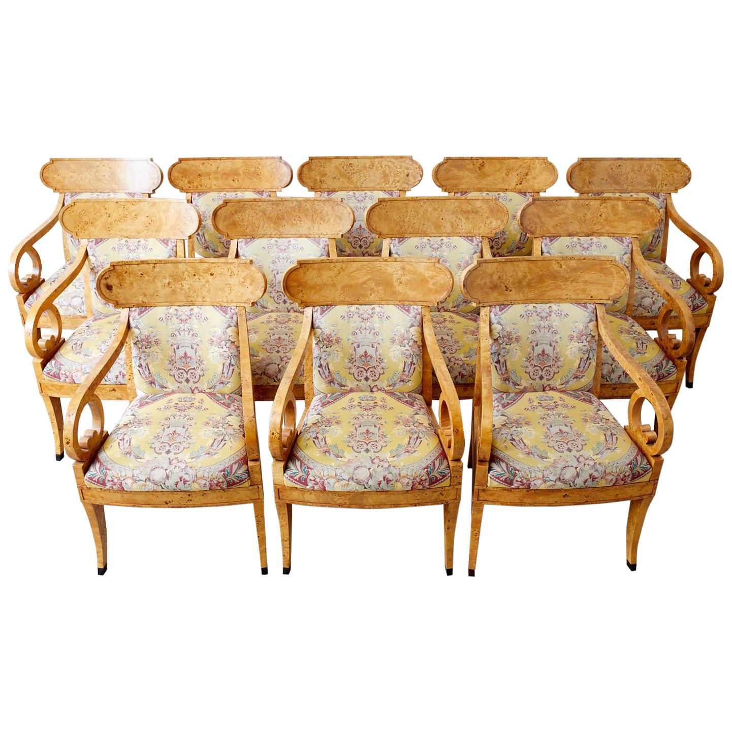 Magnificent set of twelve English Regency style klismos armchairs or dining chairs made by Baker Furniture. Featuring handcrafted frames covered with dramatic burlwood veneers. The klismos form curved backrest is conjoined by gracefully curved arms