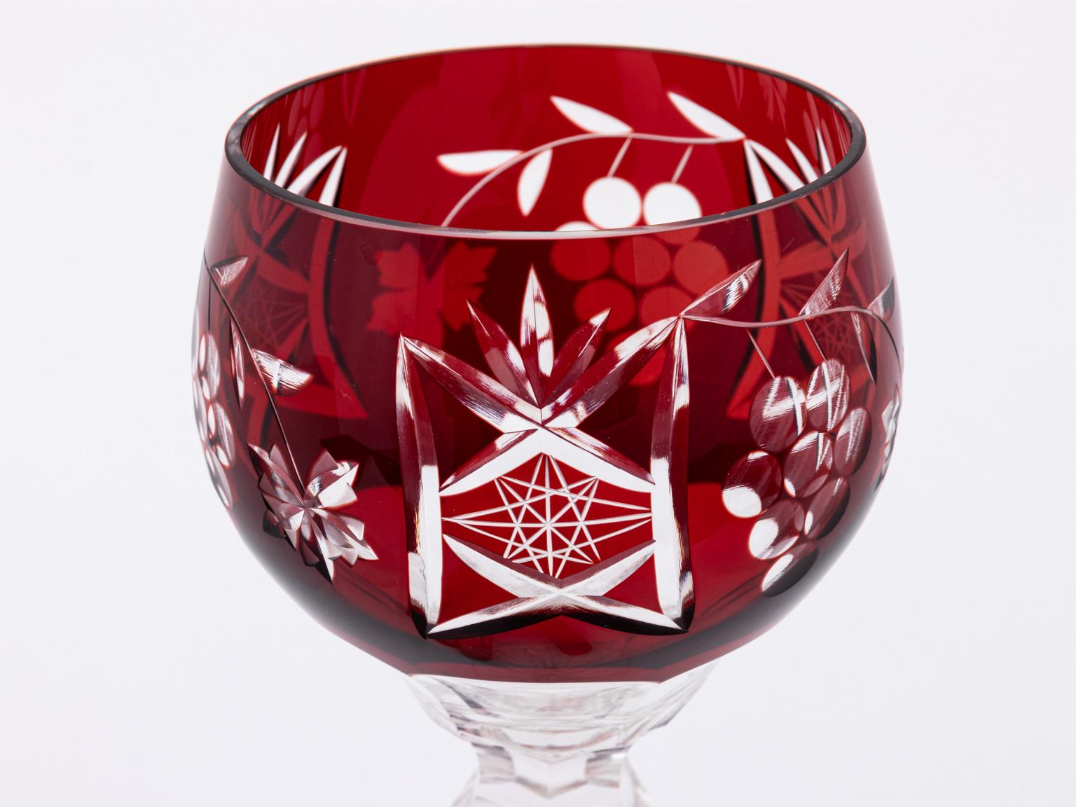 Set of twelve crystal Bohemian hock wine glasses in an a combined starburst and grapevine pattern placed on cut glass stems, circa mid-20th century modern. The set includes two pairs of the following colors: Amber, amethyst, burgundy, ruby, cobalt,