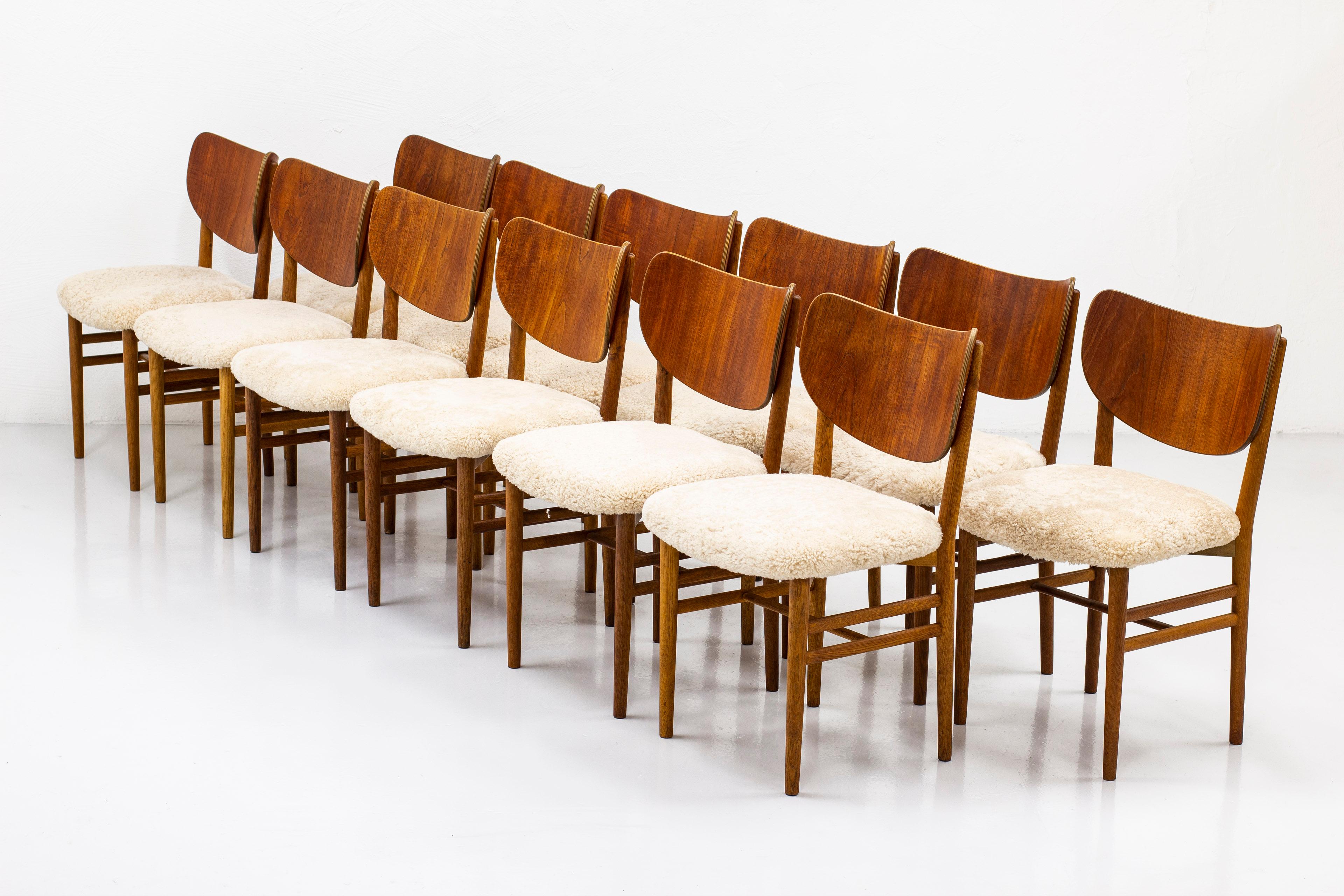 Set of twelve dining chairs designed by Nils & Eva Koppel. Produced in Denmark by Slagelse Møbelvaerk during the 1950s. Made from solid oak in the leg frame and laminated teak in the back rest. Reupholstered with whole sheepskin fur in creme colour.