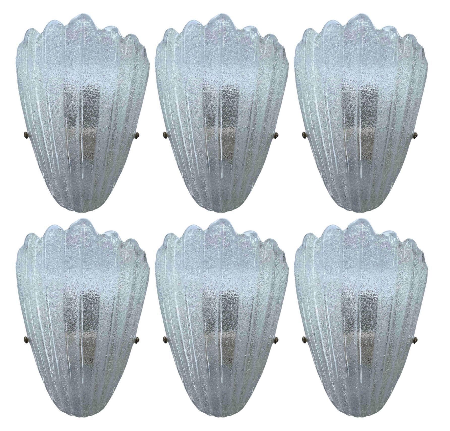 Set di dodici appliques d'epoca italiane con paralume in vetro di Murano trasparente soffiato a mano con texture granulare con tecnica Graniglia e montate su una struttura in metallo bianco. Realizzato in Italia, anni '60.
Misure: larghezza 9,5