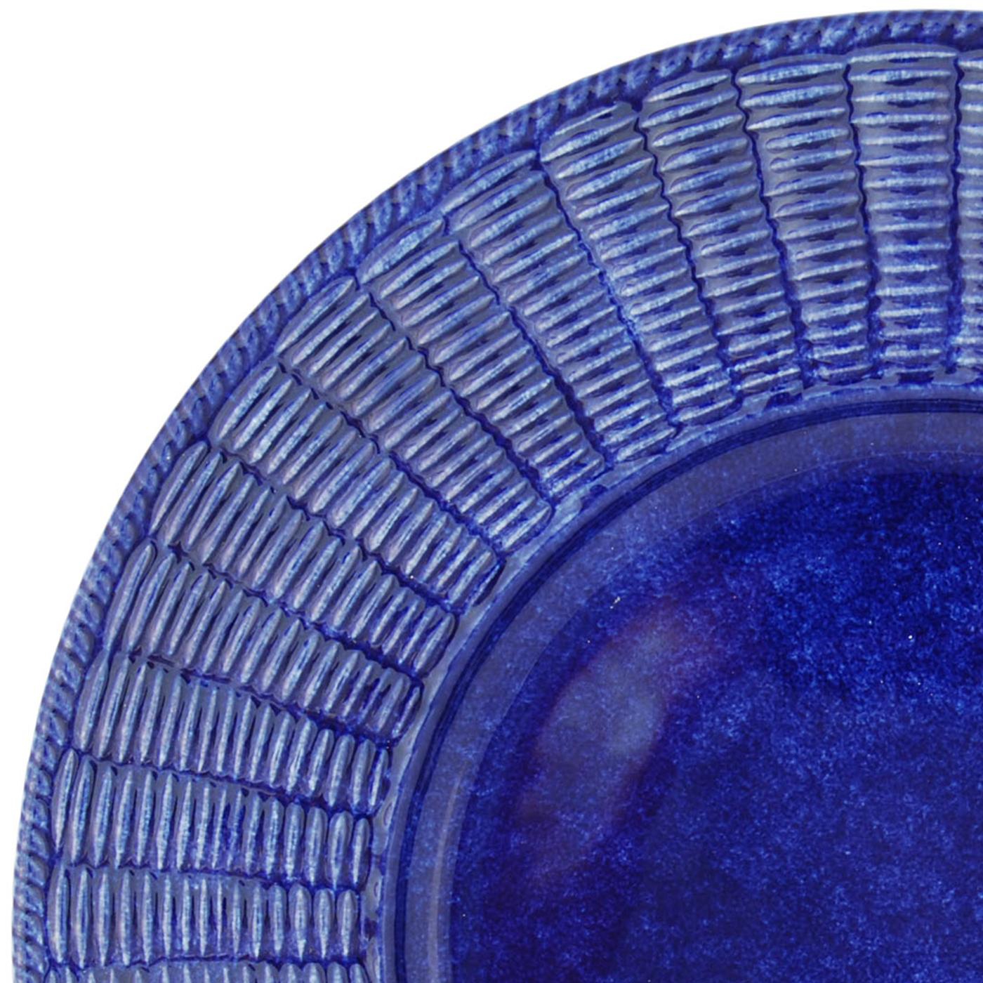 This is a set of twelve large plates conceived as placeholders, to be left as base as courses change, finished in a rich shade of blue with a sponge effect. The pieces are characterized by Este Ceramiche's signature wicker border, flawlessly created