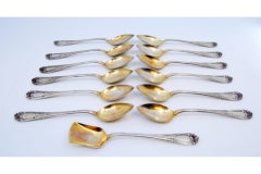 Set of twelve coffee spoons & sugar shovel in gilded silver w/ embossed handles