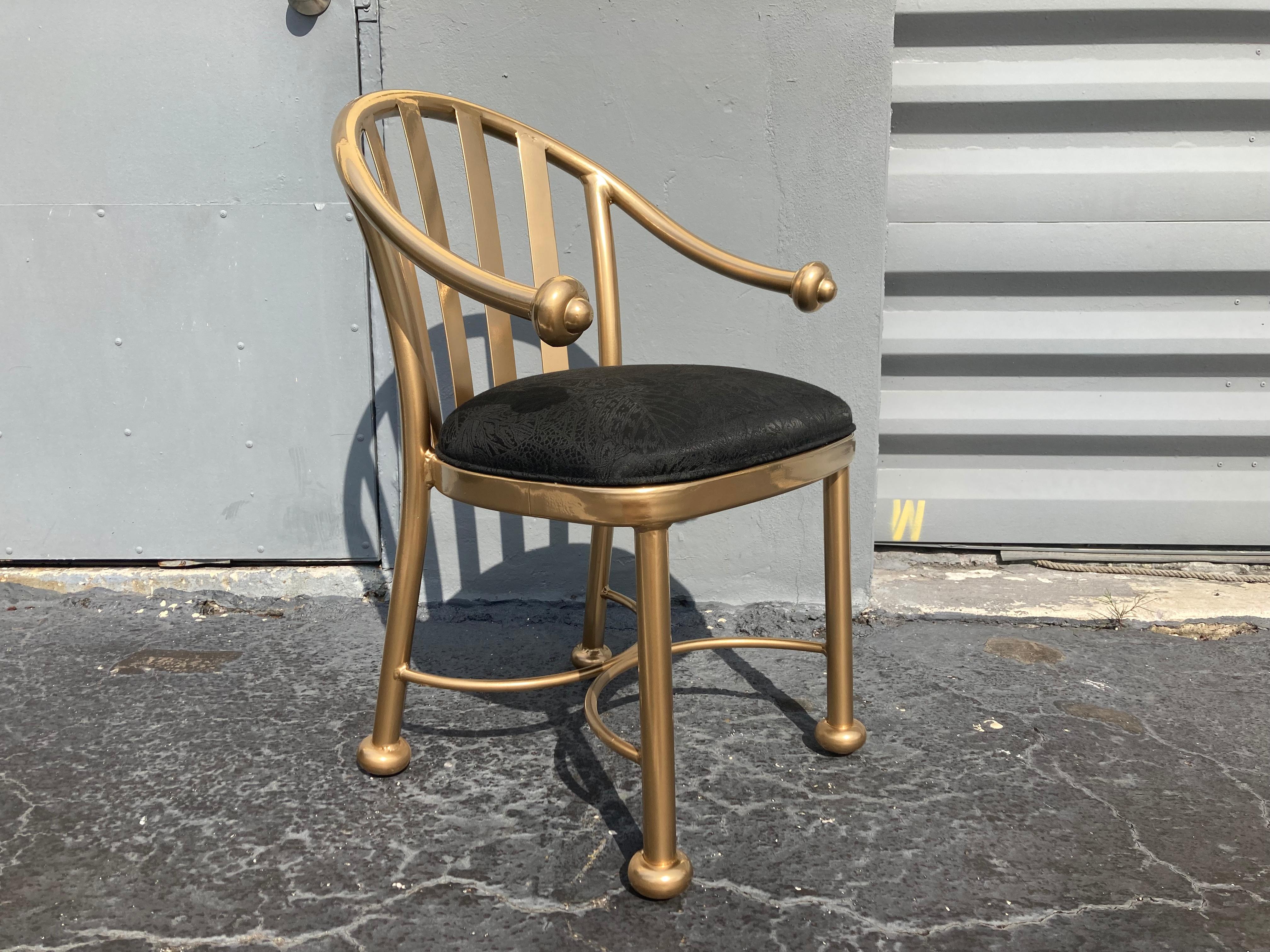 Set of twelve dining chairs, gold painted aluminum frames with fabric seats. Finish has almost a polished brass look. Front arm height is about 24”.