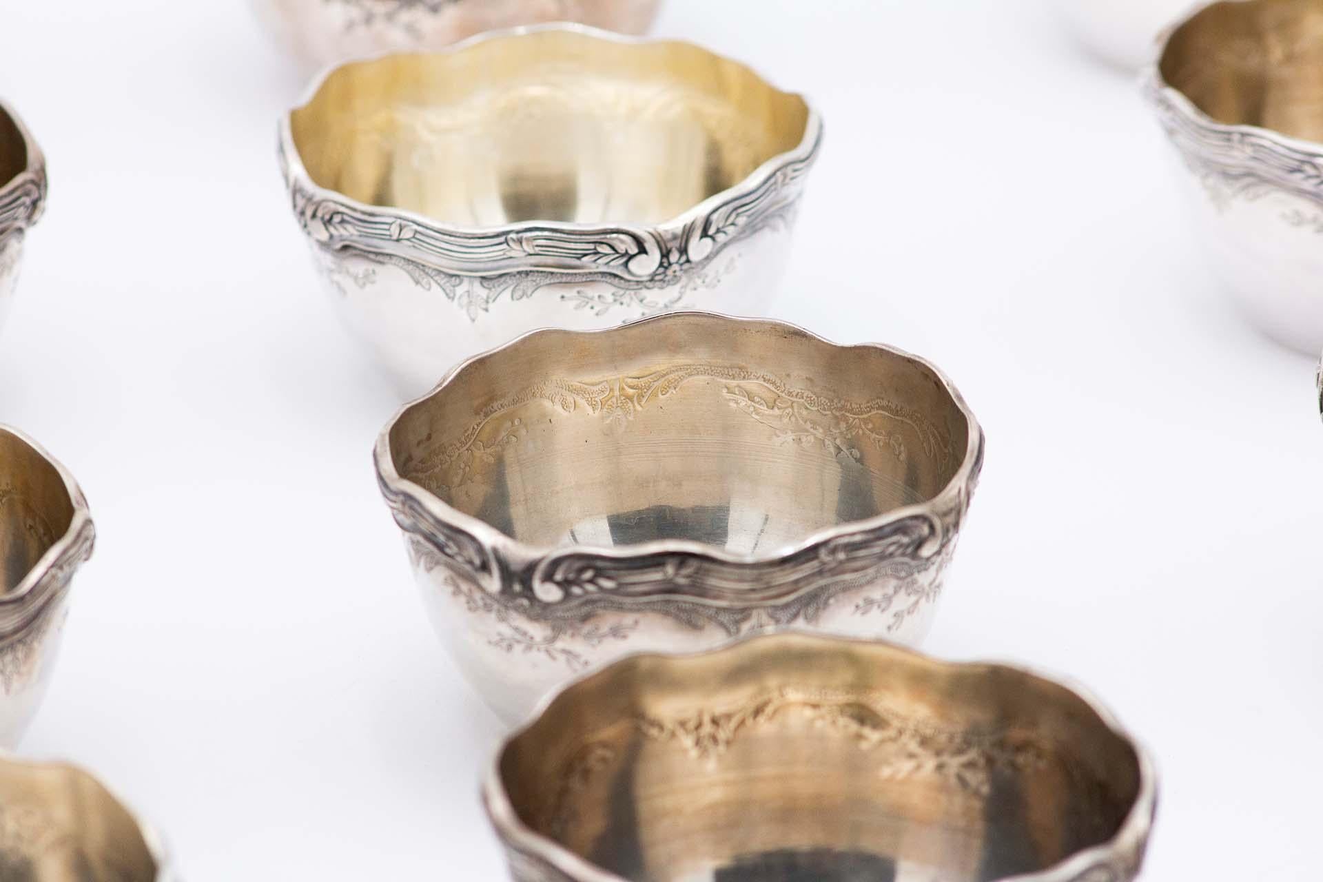 Description: Set of twelve washbasins in embossed silver. Metal: Silver. Origin: Portuguese. Mark: standing eagle - I Title. Weight: 2375.45 grams. Dimensions: 11.5cmx5.9cm. Content: 916/1000. Assay Mark: Yes, between 1938 and 1984. Additional