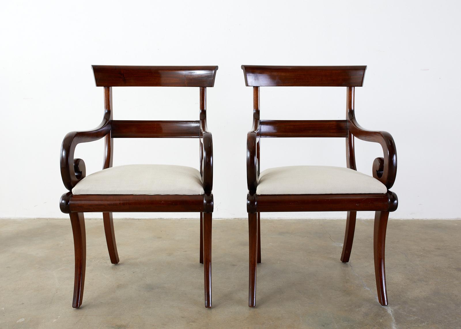 Handsome set of twelve late 19th century English mahogany dining chairs made in the Regency taste. The set consists of 10 side chairs and 2 armchairs measuring 22