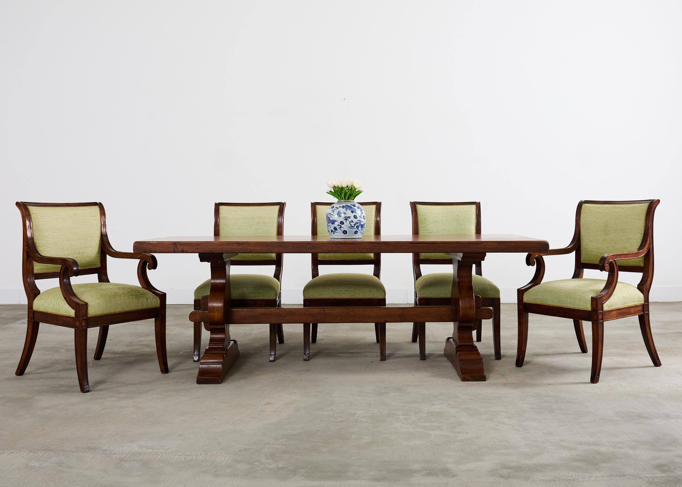 Grand set of twelve distinctive dining chairs crafted from walnut. The set consists of ten dining chairs and two host armchairs. The walnut frames have a later restoration and upholstery by L. Rossi in San Francisco, CA. The chairs feature