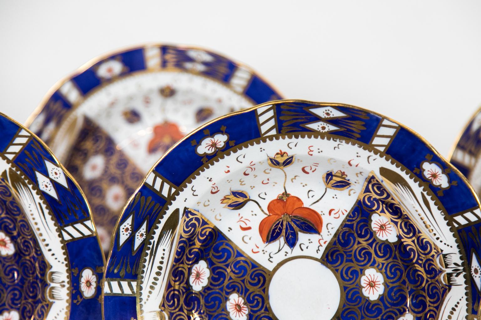 These twelve English Staffordshire soup plates are decorated with stylized flowers with alternating lozenges containing gilt arabesques and whimsical dashes. The gilded highlighting has survived in superb condition, and the overall condition is