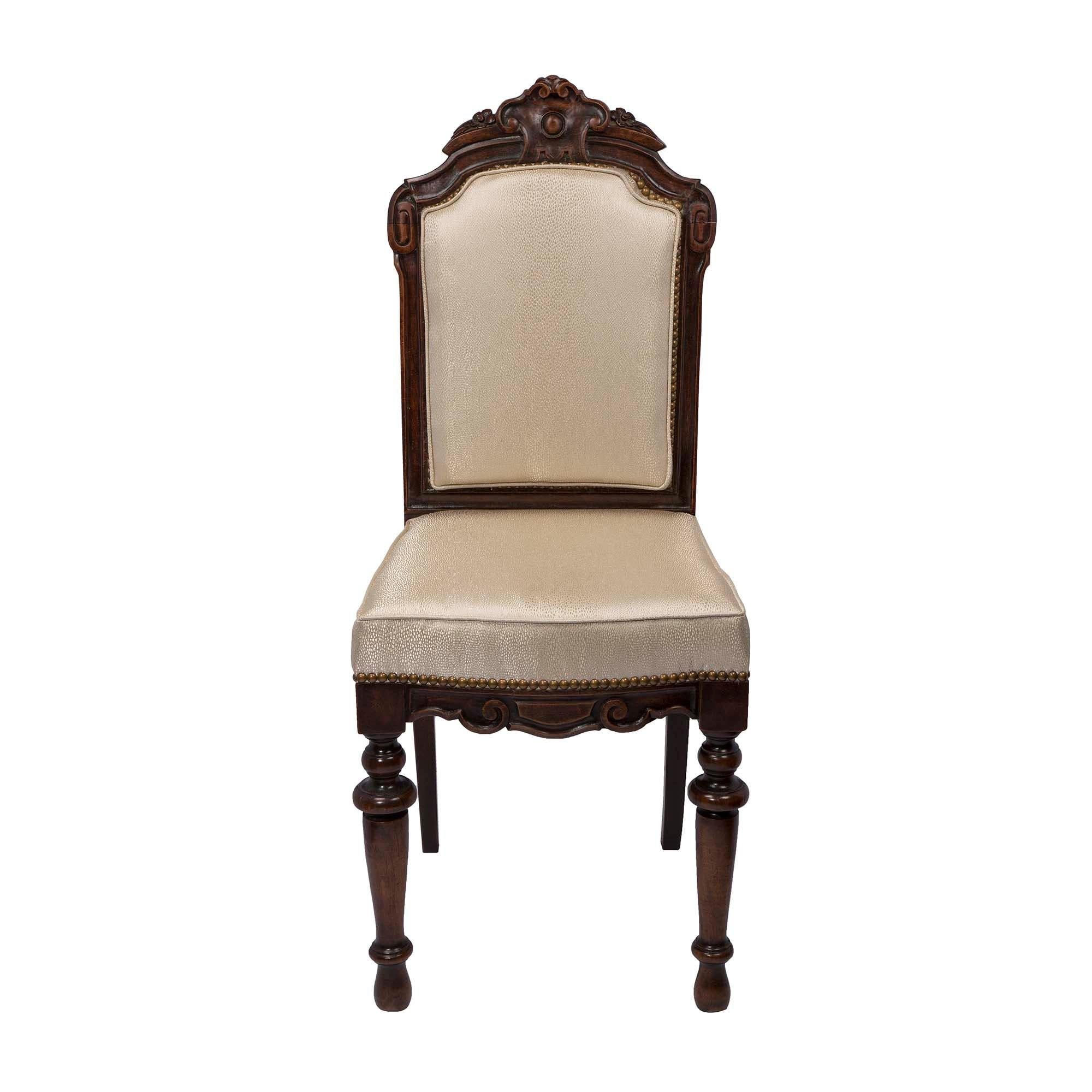 A unique and complete set of twelve French 19th century walnut dining chairs. Each chair is raised on tapered legs at the front, and straight legs in the back. The arbalest shaped frieze has wonderful scrolled carvings, at the front. A cabochon