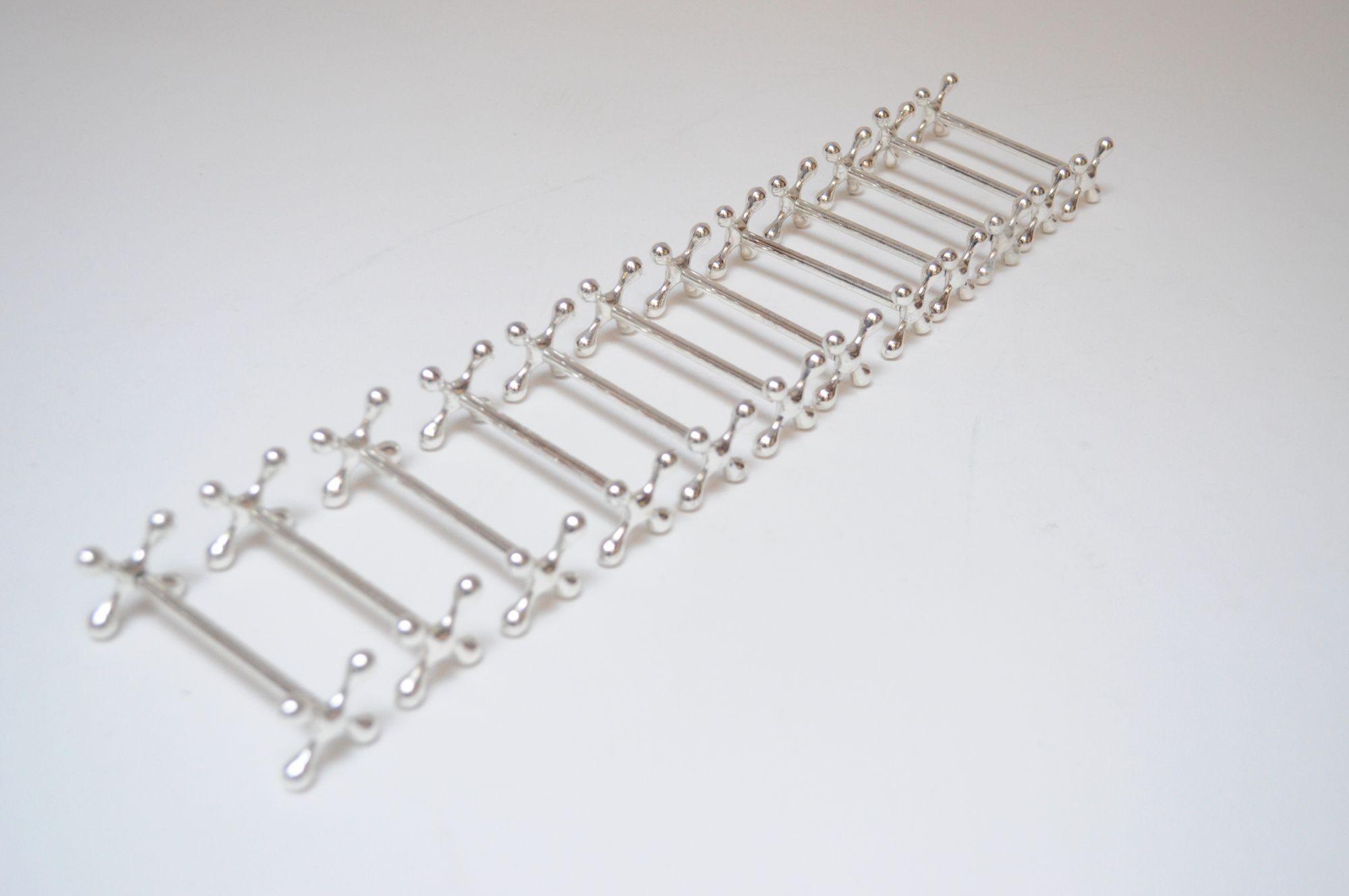 Set of Twelve French Deco Jax / X-form mitred silver-plated knife rests (ca. 1940s, Italy).
In the style of Christofle, but unsigned. There is an illegible hallmark to a few of the rests, but the branding is too small to decipher.
Unpolished