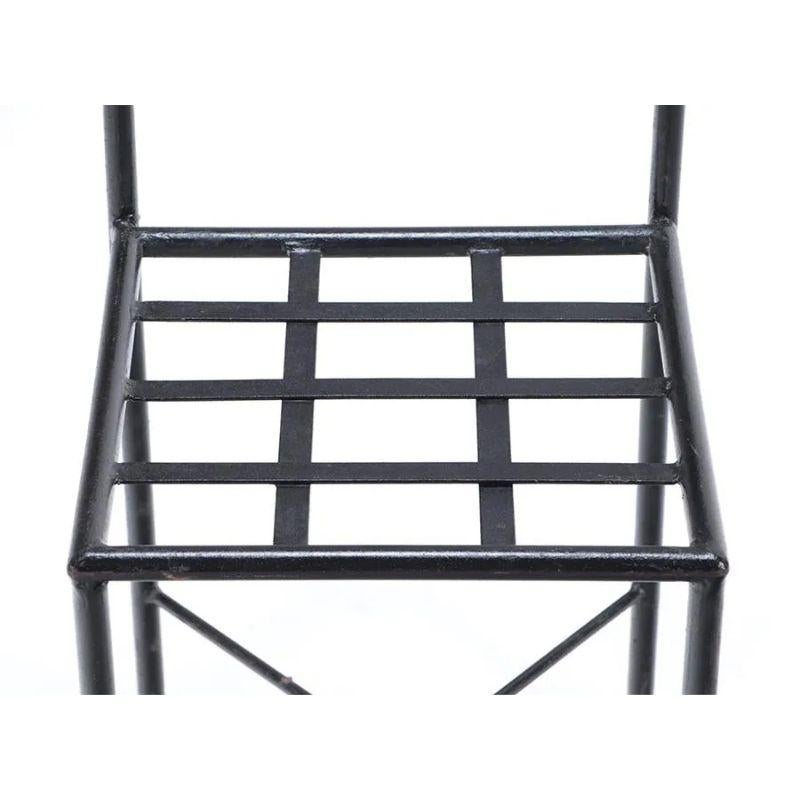 A set of twelve French iron X back chairs, perfect for outdoor dining. The set of black chairs with a narrow profile have a lattice grid seat and an X design to the back that is both decorative and a chair back support.  Each chair features an X