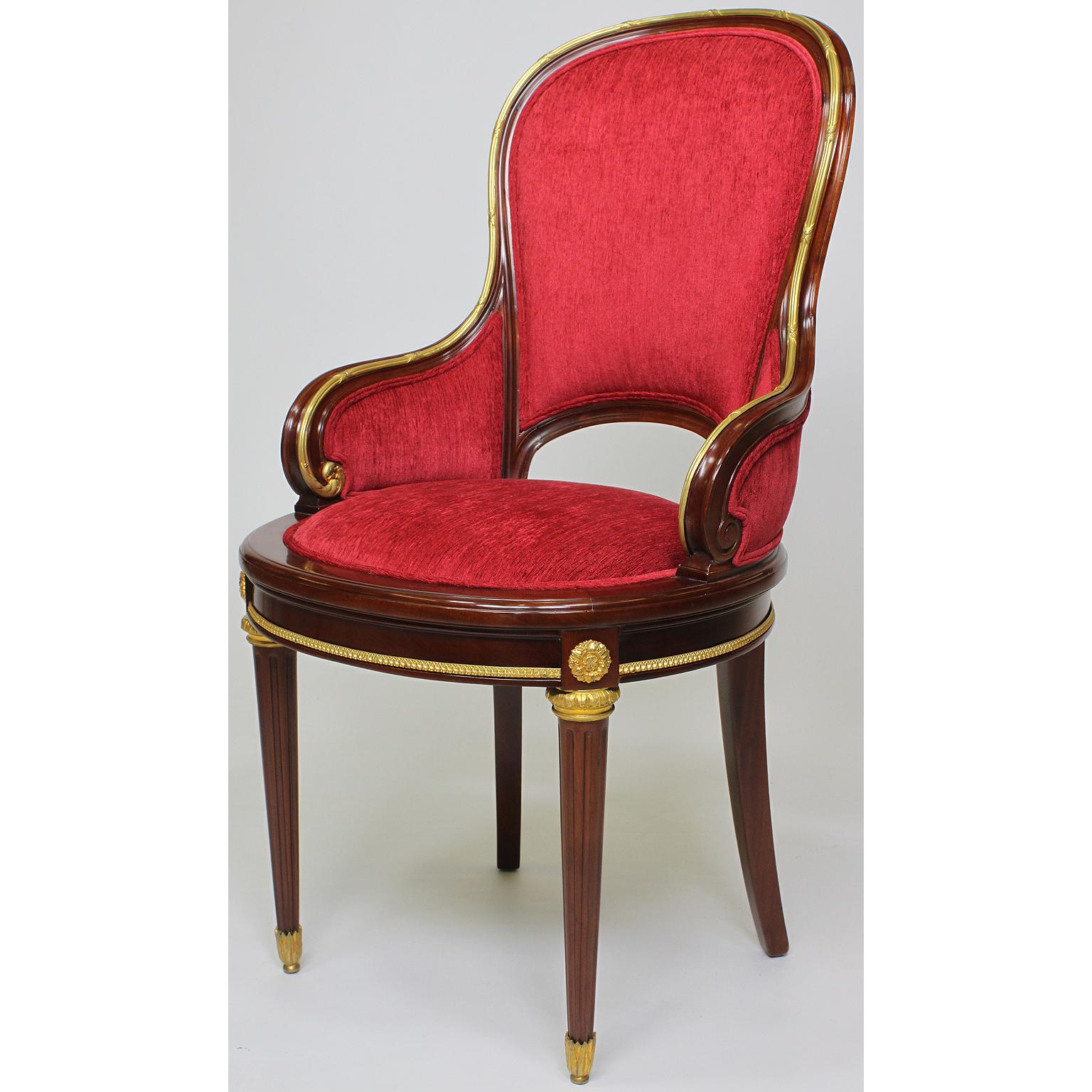 A very fine set of twelve French 19th-20th century Louis XVI style Belle Époque mahogany and ormolu-mounted dining chairs. The rounded and padded backrests and sides, surmounted with a banded gilt bronze trim and medallions, raised on fluted legs