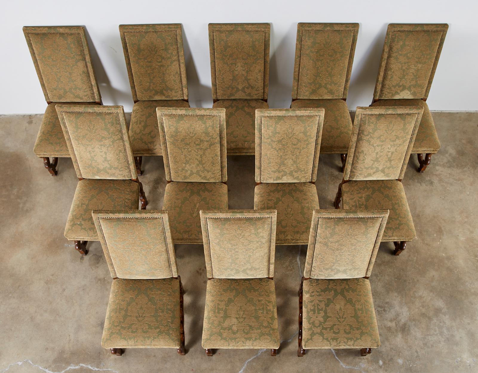 Bespoke set of twelve upholstered dining chairs made in the French Louis XIV taste also known as Os de Mouton chairs. The matching chairs feature a textured fabric in moss green and camel hair color with a subtle foliate design. The fabric is