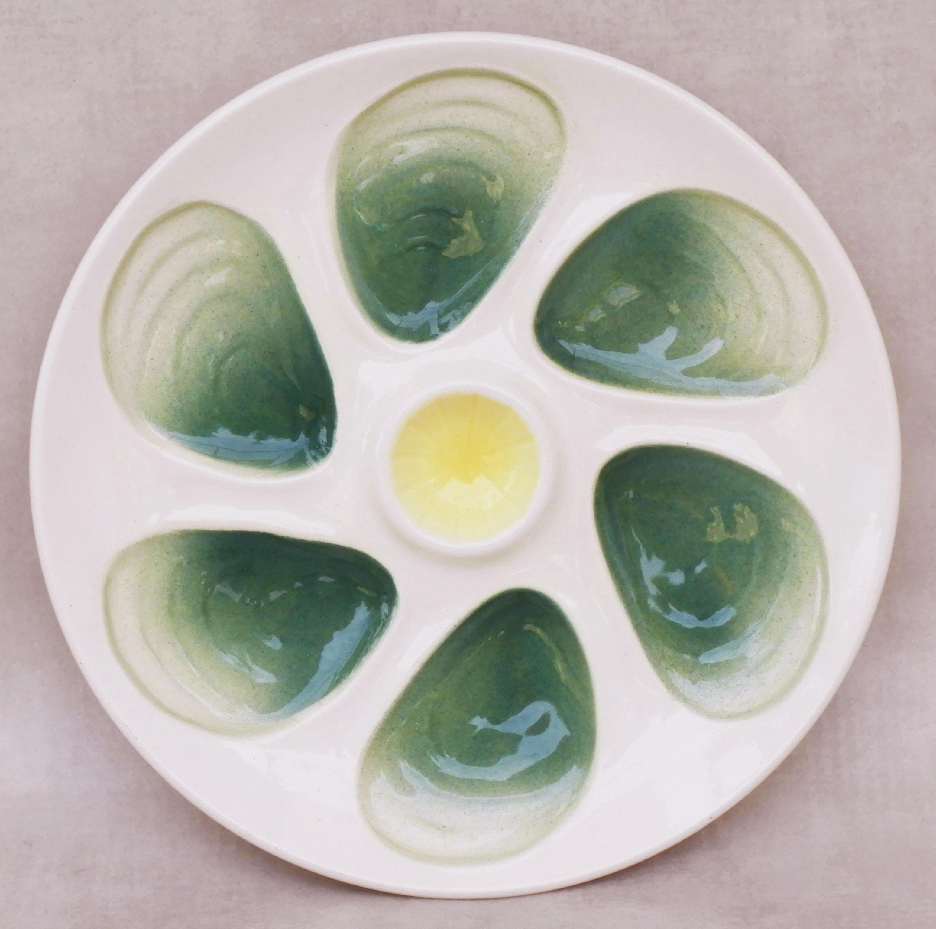 A set of a dozen French mid-century modern oyster plates in green, white and yellow glazed faience.
Twelve stylish high-glazed platters, all in very good vintage condition with no chips or losses.
Each of the twelve plates measures 9.65″ (24.5cm) in