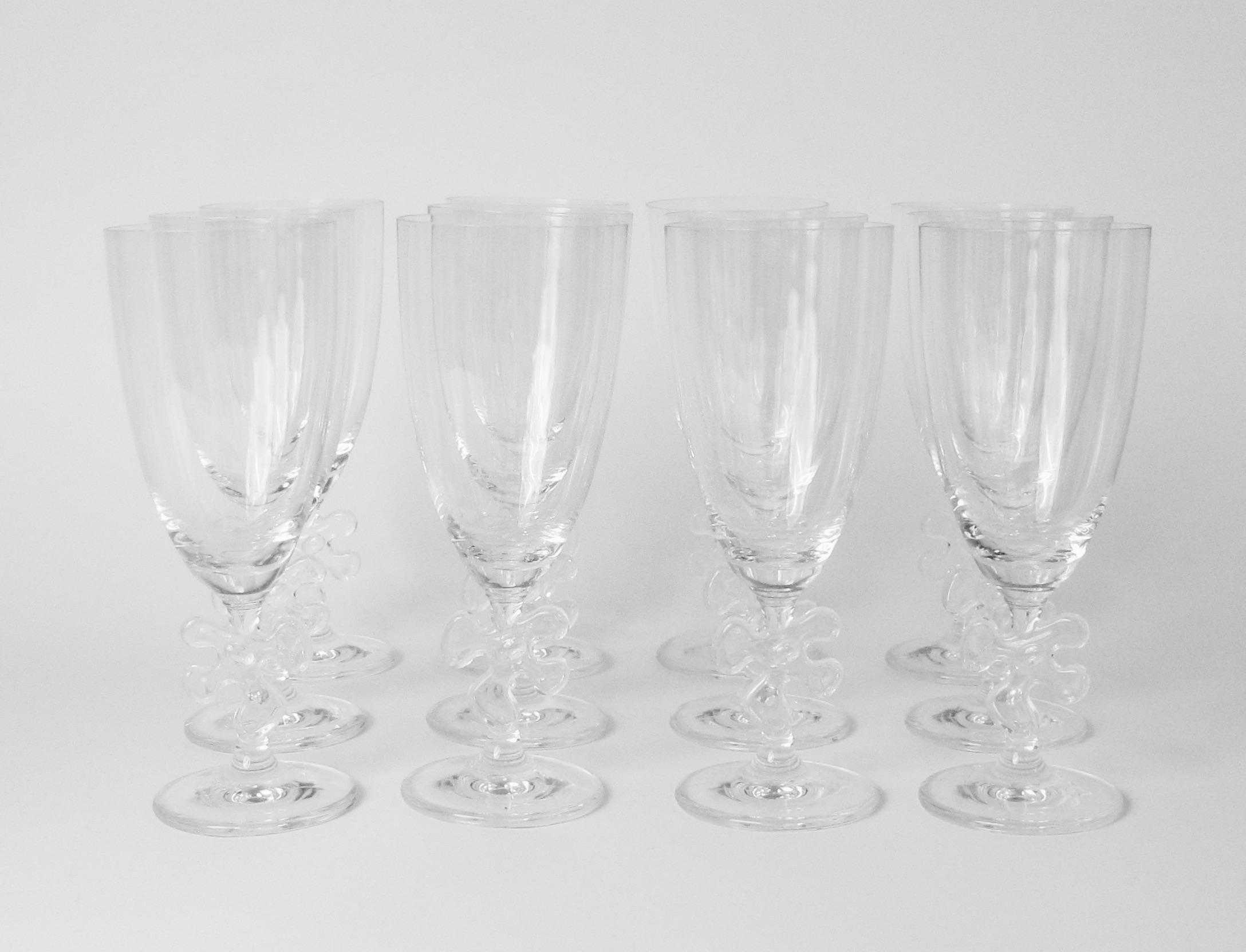 Large set of twelve Water glasses by Marc Auer . Whimsy and elegance crystal glass on jigsaw embellished stem . Acid stamped Marc Auer .