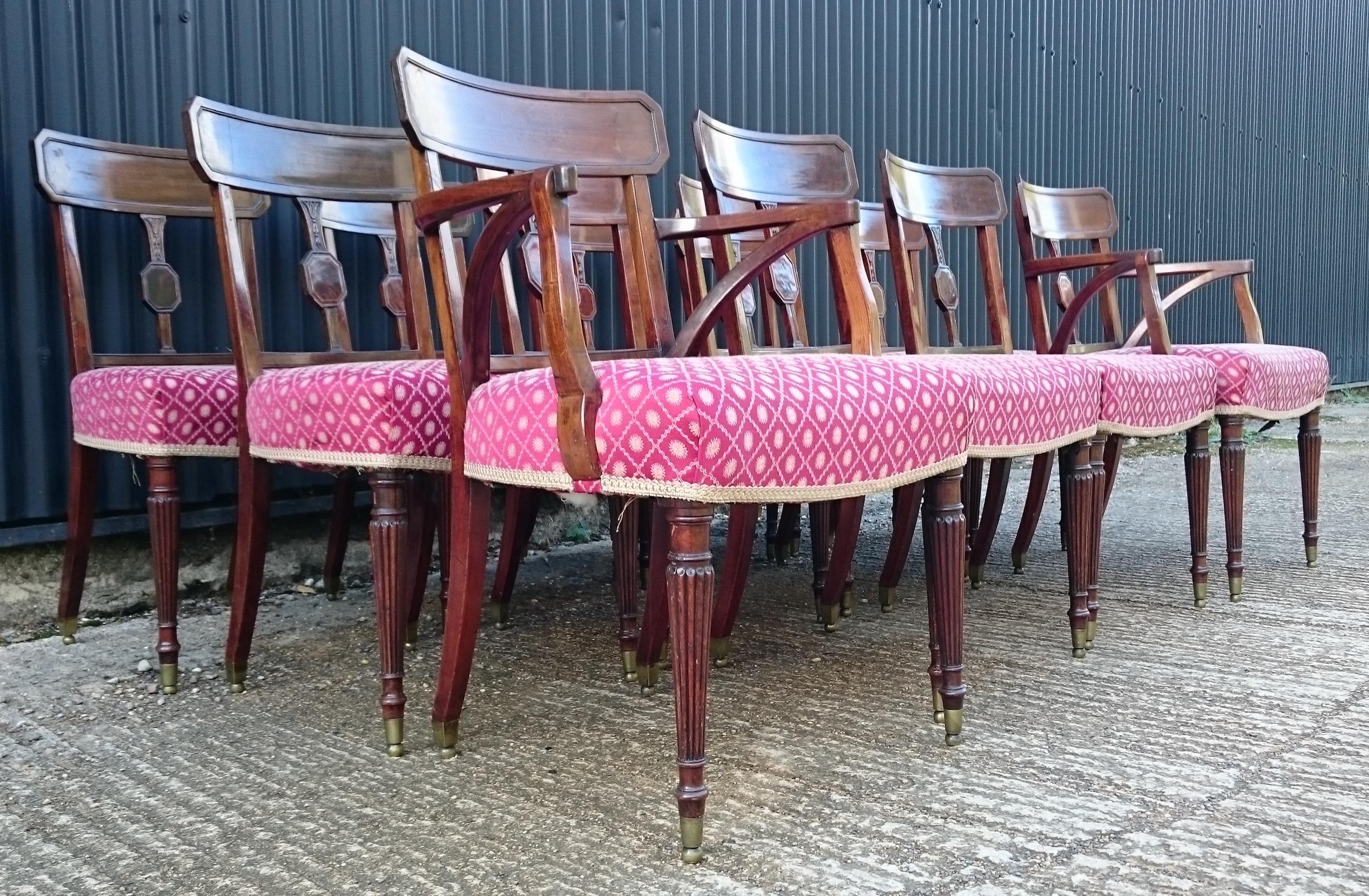 Set of twelve George III period mahogany antique dining chairs, ten singles and two armchairs, standing on elegant turned legs with good close reeded decoration and unusual brass caps. These chairs have been re-railed using good quality close