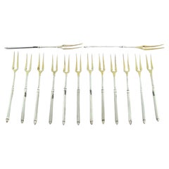 Set of twelve gilded silver pickle forks with raised handles