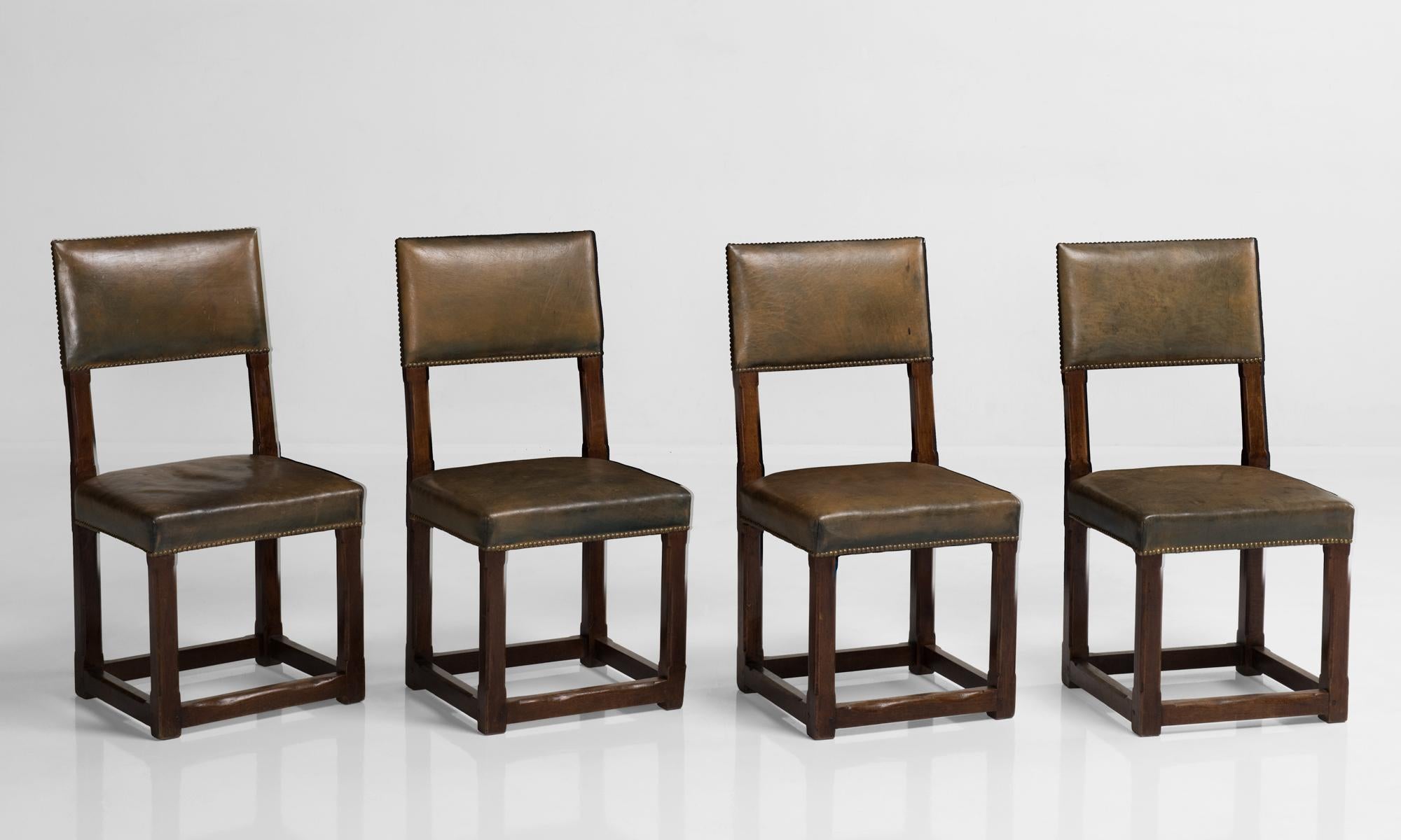 Set of twelve Gothic oak and leather dining chairs, England circa 1880.

Oak frame with leather seat and back. Designed in the manner of Pugin, and originally used in the House of Commons.