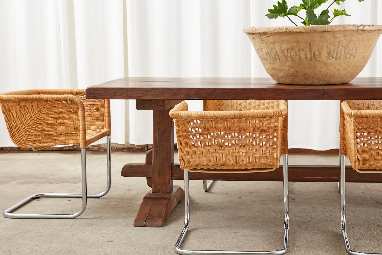 Fantastic Mid-Century Modern set of twelve wicker basket chairs by Harvey Probber. Model D43 cantilever chairs constructed from a chromed steel tube frame with a woven rattan wicker basket style seat. The wicker has a beautifully woven rattan fan