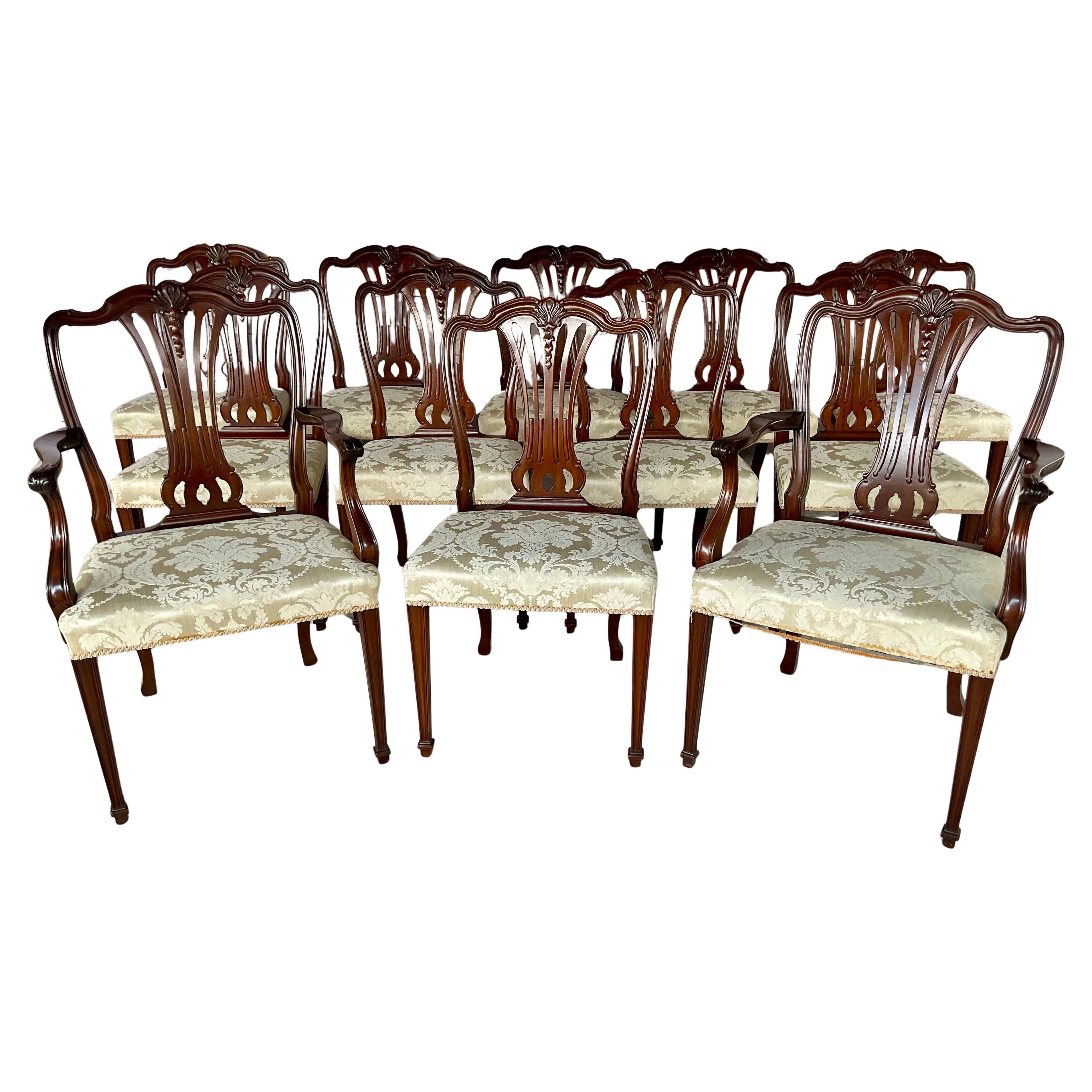 Set of twelve Hepplewhite Style Mahogany Dining Chairs. Set is comprised of two armchairs and ten side chairs. These elegant chairs are a faithful revival of the iconic late 18th century English cabinetmaker George Hepplewhite, whose work defined