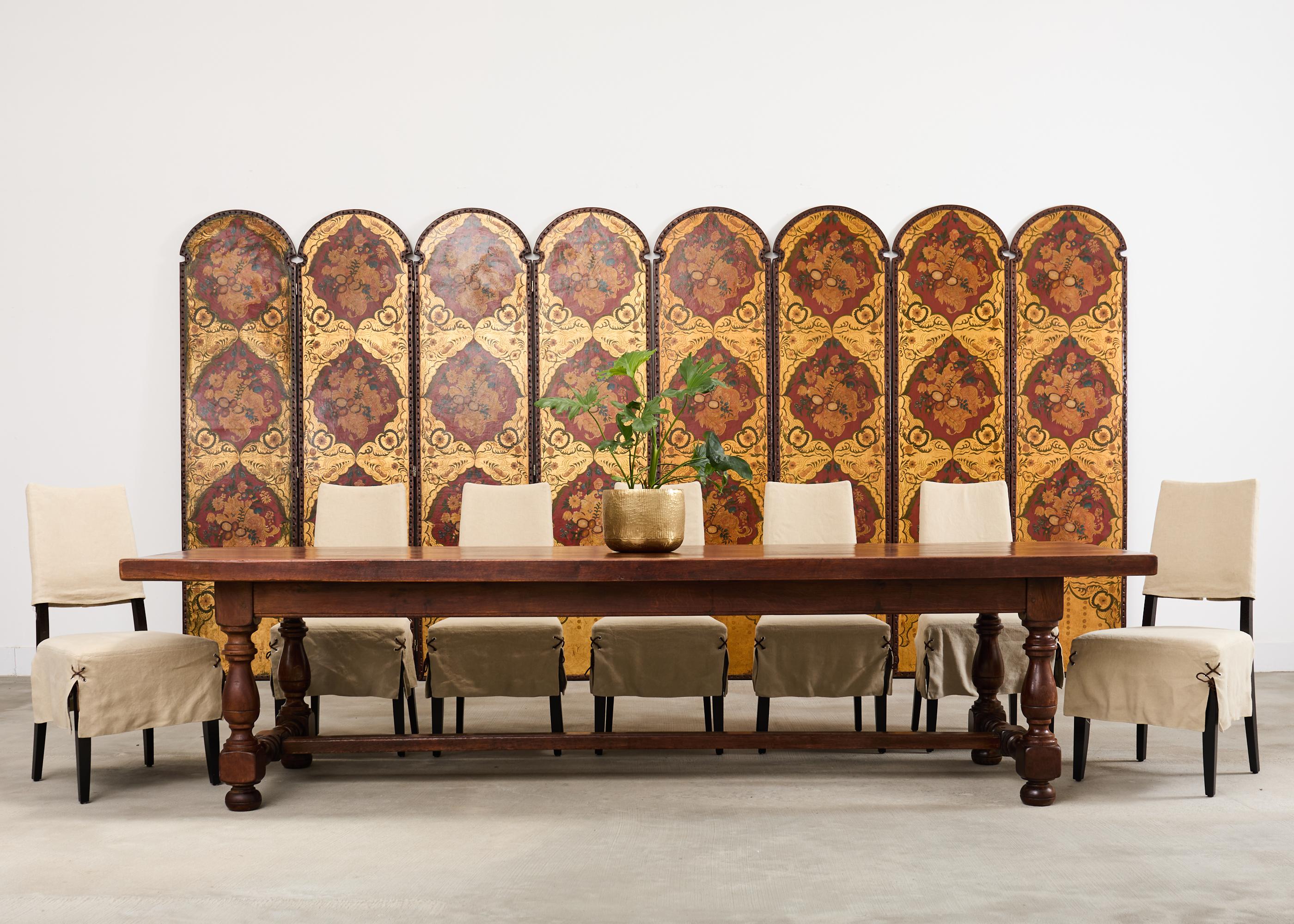 Chic bespoke set of twelve hardwood dining chairs featuring 2-piece slipcovers with leather laces. The chairs feature an ebonized hardwood frame that tapers towards the top. The bold architectural lines are softened by the tailored slipcovers